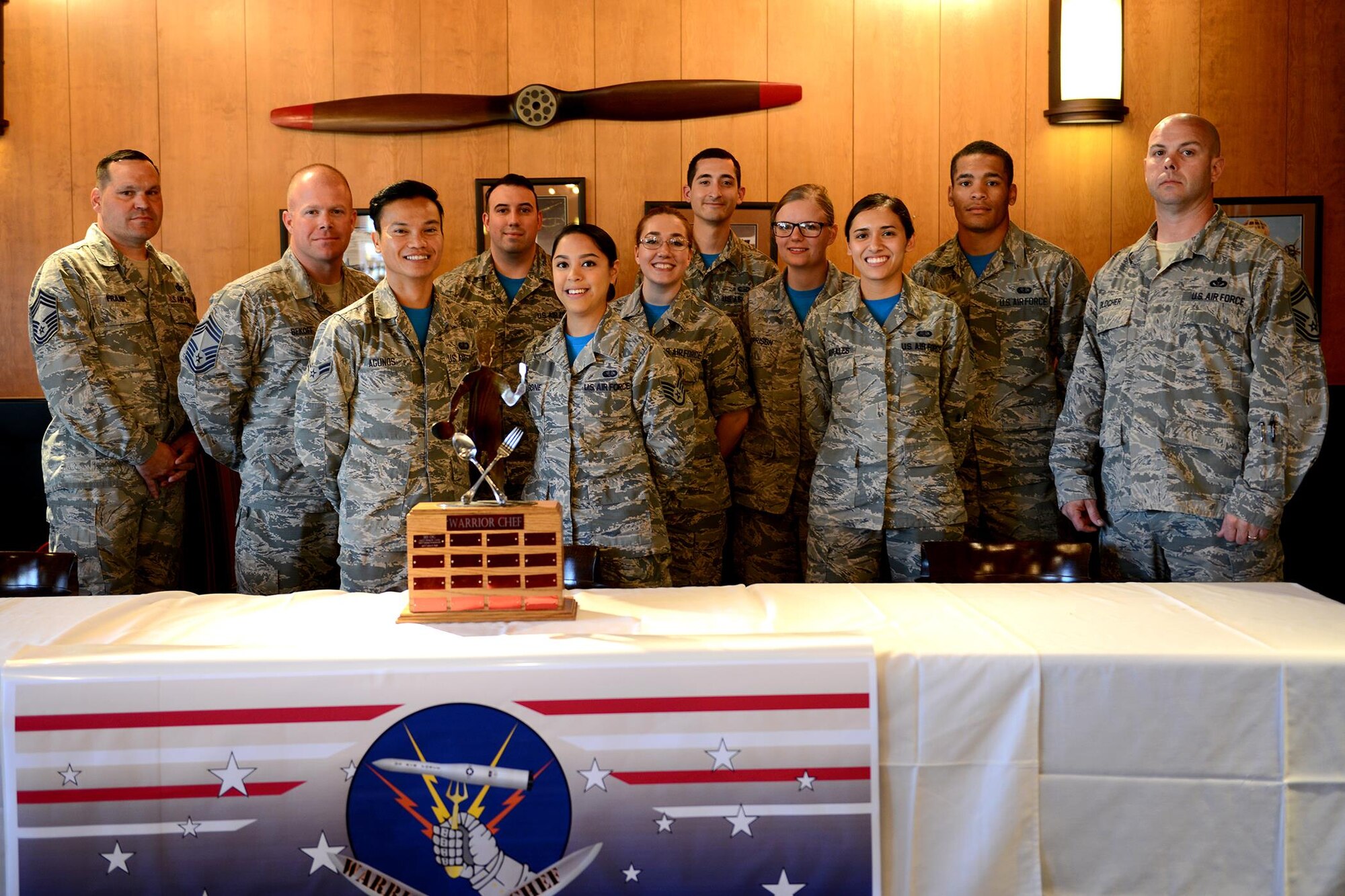 Warrior Chef teams and judges pose for a photo after the Warrior Chef competition at the Grizzly Bend, June 7, 2017 at Malmstrom Air Force Base, Mont. Four teams of two had an hour to prepare meals from scratch using fresh ingredients and incorporating mangoes as the secret ingredient.   (U.S. Air Force photo/Staff Sgt. Delia Marchick)