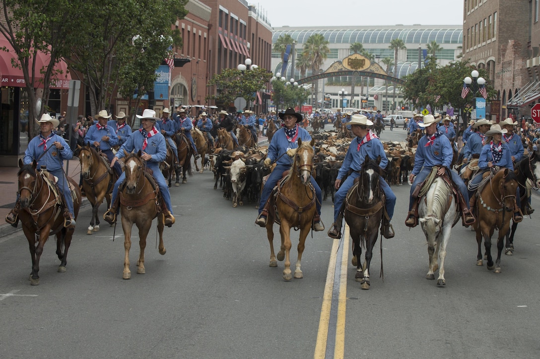 U.S. Marine Corps Brig. Gen. Kevin J. Killea, Marine Corps Installations West, Marine Corps Base, Camp Pendleton, and members of the San Diego County fair participate in a cattle drive throughGas Lamp District in San Diego, Calif., June 3, 2017. The San Diego County Fair hosted the drive as a part of the gas lamp district's 150th anniversary and to promote the county fair that opened June 2. (U.S. Marine Corps photo by Lance Cpl. Brooke Woods)