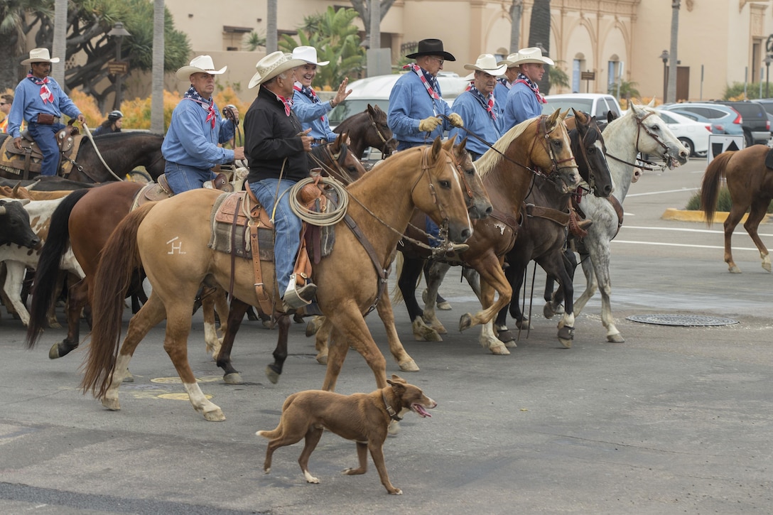 U.S. Marine Corps Brig. Gen. Kevin J. Killea, Marine Corps Installations West, Marine Corps Base, Camp Pendleton, and members of the San Diego County Fair participate in a cattle drive through the Gas Lamp District in San Diego, Calif., June 3, 2017. The San Diego County Fair hosted the drive as a part of the gas lamp district's 150th anniversary and to promote the county fair that opened June 2. (U.S. Marine Corps photo by Lance Cpl. Brooke Woods)