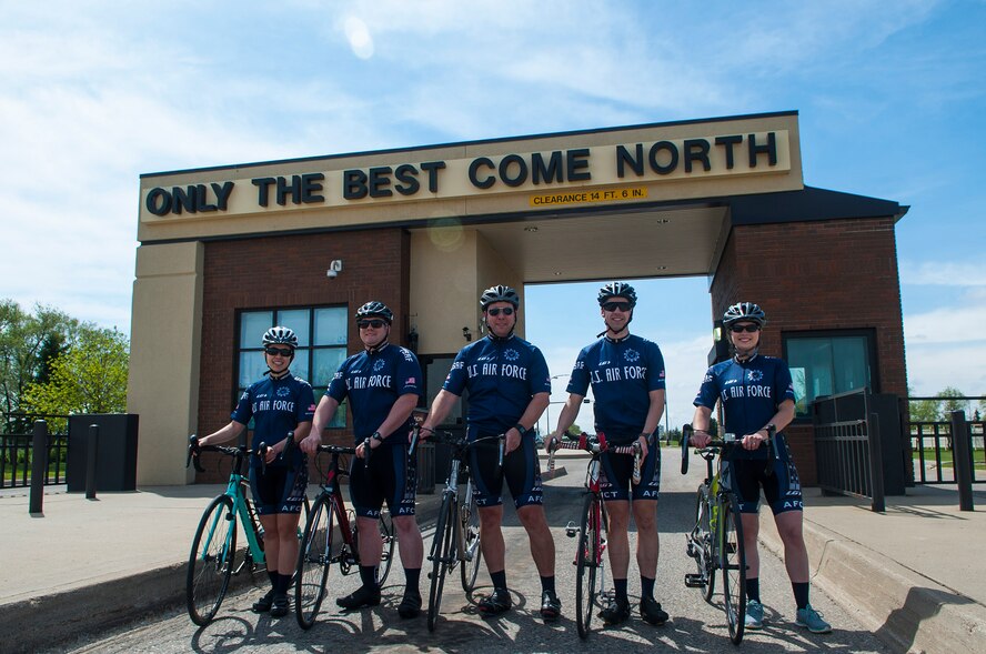 Members of the Air Force Cycling Team stand in front of the gate at Minot Air Force Base, N.D., May 17, 2017. There are six Minot Air Force Base Airmen on the Air Force Cycling Team, which has more than 150 cyclists Air Force-wide. (U.S. Air Force photo/Airman 1st Class Jonathan McElderry)