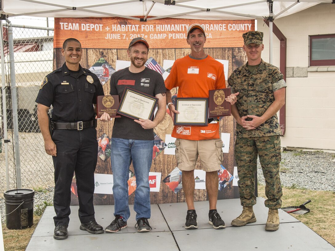 Representatives of Habitat for Humanity and Home Depot receive Certificates of Appreciation from Marine Corps Base Camp Pendleton during the K9 upgrade project aboard Camp Pendleton, Calif, June 7, 2017. Volunteers painted and repaired kennels as well as constructed a new shade structure and obstacle courses to increase the quality of training.