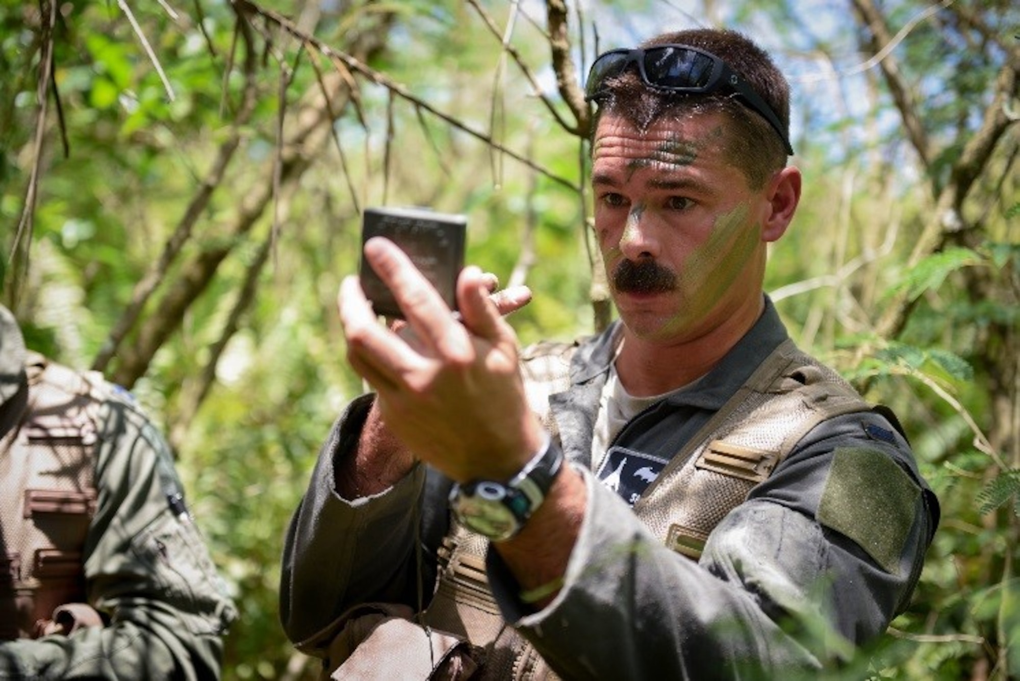 U.S. Air Force 1st Lt. Manuel Lamson, 9th Expeditionary Bomb Squadron weapon systems officer, applies camouflage face paint during a combat search and rescue training exercise June 5, 2017, at Andersen South, Guam. During the exercise, Lamson acted as a downed aircrew member, along with three other Airmen, and was tested on his ability to survive and evade in a jungle environment. (U.S. Air Force photo by Staff Sgt. Joshua Smoot)
