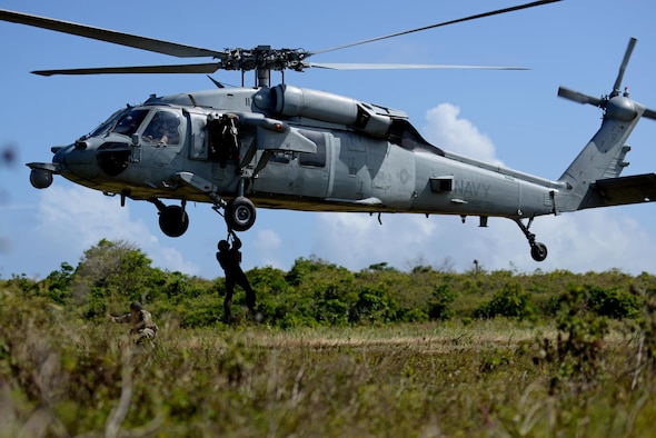 A U.S. Airman from the 9th Expeditionary Bomb Squadron descends from a U.S. Navy MH-60 Seahawk, assigned to Helicopter Sea Combat Squadron Two-Five, during a combat search and rescue training exercise June 5, 2017, at Andersen South, Guam. Service members from Task Force Talon, HSC-25, and the 36th Wing joined together to practice survival, evasion, resistance and escape procedures, emergency evacuation techniques and quick reaction force training. This is the first time these units participated in a combat search and rescue exercise together on Guam.(U.S. Air Force photo by Airman 1st Class Gerald R. Willis)
