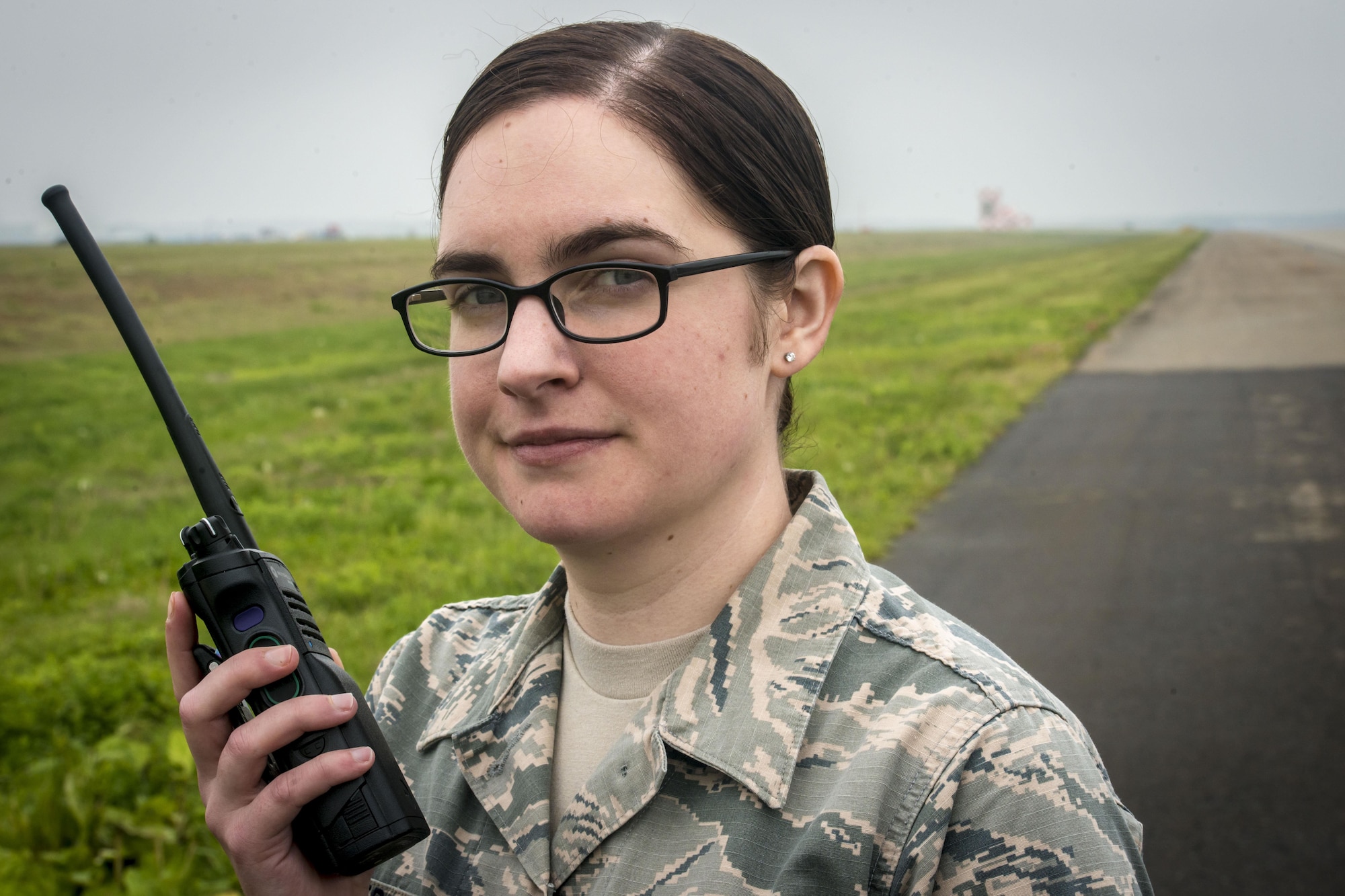 U.S. Air Force Airman 1st Class Kelly Coats, a 35th Operations Support Squadron airfield manager, poses for a photo on the flight line at Misawa Air Base, Japan, May 25, 2017. In her capacity, Coats cares for the maintenance of runways, lighting and other airfield components and systems, and helps ensure all takeoffs and landings can proceed without incident. When she’s not working, she’s drawing the base’s comic strip, “Airmanitis.” Coats’ art is her escape from reality lending to her resiliency as a warfighter in the Pacific theater. (U.S. Air Force photo by Tech. Sgt. Benjamin W. Stratton)
