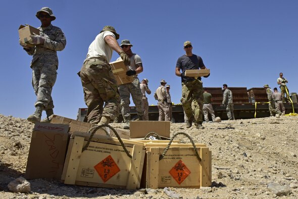 Members from the 407th Air Expeditionary Group unload ordnance and munitions from a trailer during an explosive ordnance disposal (EOD) operation in Southwest Asia, June 6, 2017. Personnel from the 407th Expeditionary Civil Engineer Squadron EOD, U.S. Marine Corps Special Marine Air Ground Task Force EOD and Italian Air Force members completed the task of disposing of more than 5,000 pieces of expired 30 mm rounds and aircraft decoy flares. EOD’s mission is to protect personnel, resources, and the environment from hazardous explosive ordnance, improvised explosive devices and weapons of mass destruction, which may include; incendiary, chemical, biological, radiological, and nuclear hazards.  They specialize in tools, techniques and personal protective equipment to detect or identify, monitor, evaluate, interrogate, mitigate, render safe, recover, and disposal operations on ordnance or devices delivered, placed, or made dangerous by any circumstances. (U.S. Air Force photo by Senior Airman Ramon A. Adelan)