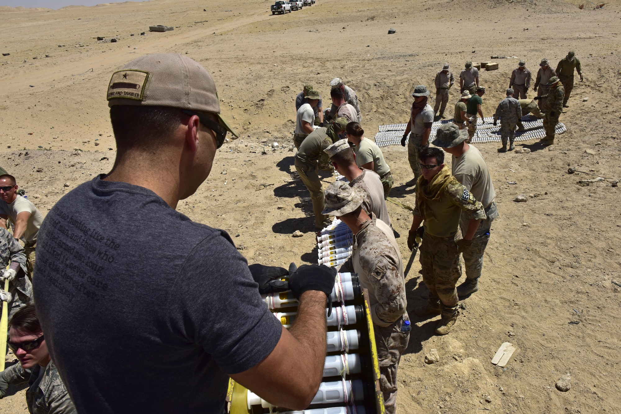 Members from the 407th Air Expeditionary Group unload munitions from a trailer during an explosive ordnance disposal (EOD) operation in Southwest Asia, June 6, 2017. Personnel from the 407th Expeditionary Civil Engineer Squadron EOD, U.S. Marine Corps Special Marine Air Ground Task Force EOD, Italian Air Force members and 407th Air Expeditionary Group personnel completed the task of disposing of more than 5,000 pieces of expired 30 mm rounds and aircraft decoy flares. EOD’s mission is to protect personnel, resources, and the environment from hazardous explosive ordnance, improvised explosive devices and weapons of mass destruction, which may include; incendiary, chemical, biological, radiological, and nuclear hazards.  They specialize in tools, techniques and personal protective equipment to detect or identify, monitor, evaluate, interrogate, mitigate, render safe, recover, and disposal operations on ordnance or devices delivered, placed, or made dangerous by any circumstances. (U.S. Air Force photo by Senior Airman Ramon A. Adelan)