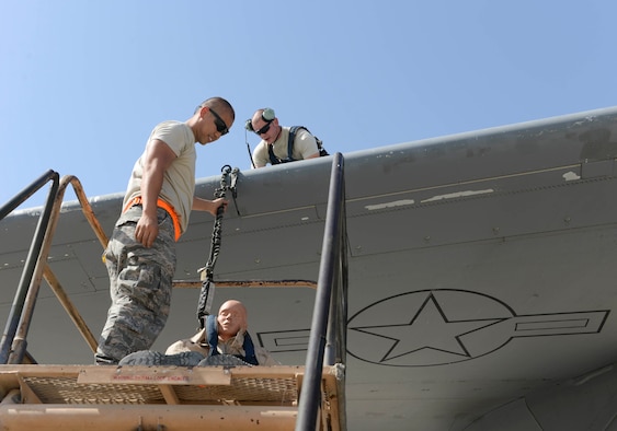 U.S. Air Force Airman 1st Class Jacob Trimble, guidance and control technician, fastened a fall restraint system to the wing of a C-17 Globemaster III to suspend a training dummy from the wing in order to simulate an accidental fall during an exercise at Al Udeid Air Base, Qatar, June 6, 2017. The fall protection exercise was conducted by members of the 8th Expeditionary Air Mobility Squadron in support of Fall Protection Awareness Month and was designed to test the 8 EAMS’ fall protection rescue plan. (U.S. Air Force photo by Tech. Sgt. Bradly A. Schneider/Released)
