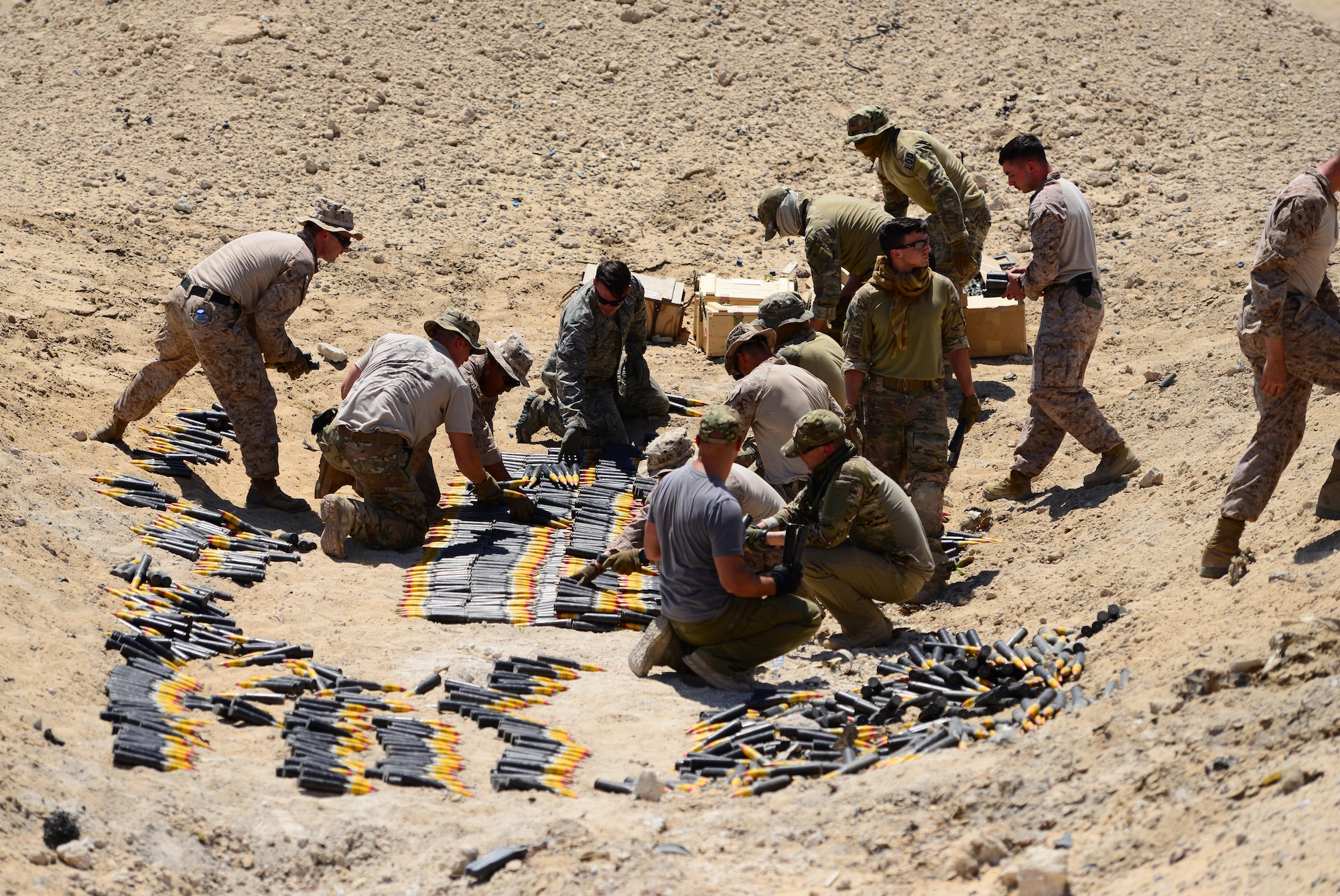 U.S. Air Force, U.S. Marine Corps and coalition partners assigned to the 407th Air Expeditionary Group prepare more than 5,000 pieces of unserviceable 30mm rounds and aircraft decoy flares for a coordinated detonation at the bomb range in Southwest Asia on June 6, 2017. Explosive ordnance disposal technicians are charged with locating, identifying, disarming, neutralizing, recovering, and disposing of hazardous explosives; conventional, chemical, biological, incendiary, and nuclear ordnance; and criminal or terrorist devices. (U.S. Air Force photo by Tech Sgt. Andy M. Kin)