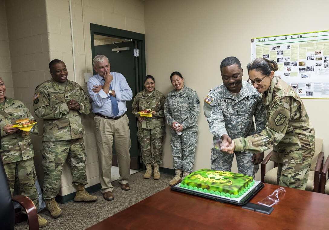 Maj. Gen. Marion Garcia, commanding general of the 200th Military Police Command, chops down on a congratulatory cake with the help of Spc. Derrick Bonney, personnel specialist, during a surprise celebration for her promotion to major general at Fort Meade, Maryland, June 8. (U.S. Army Reserve photo by Master Sgt. Michel Sauret)