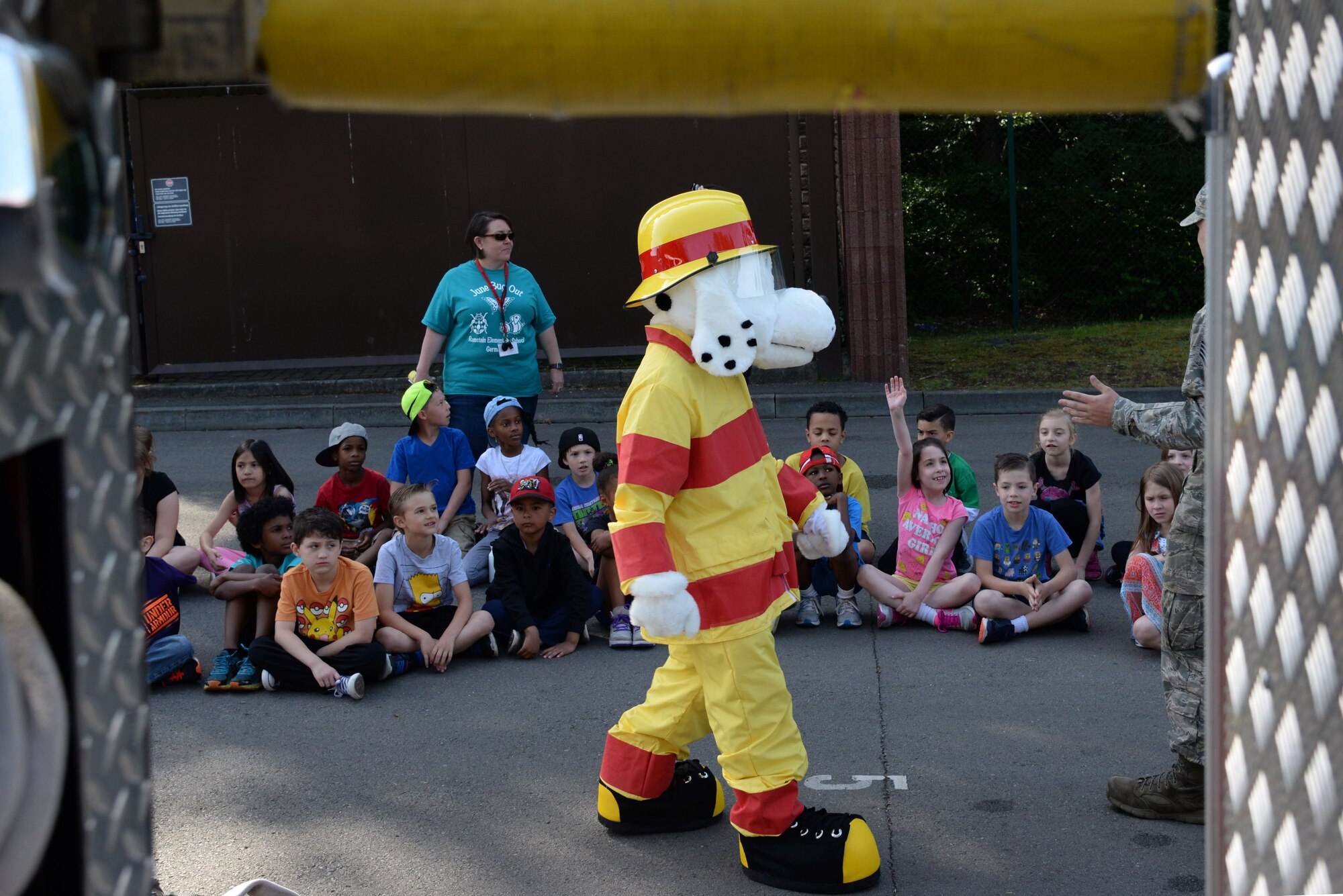 Sparky, 86th Civil Engineer Squadron fire prevention mascot, demonstrates the proper way to execute the stop, drop, and roll maneuver at Ramstein Elementary School’s June Bug Out field day on Ramstein Air Base, Germany, June 8, 2017. Groups of approximately 30 children at a time came to watch Sparky and 86th CES Airmen speak on fire safety. (U.S. Air Force photo by Airman 1st Class D. Blake Browning)