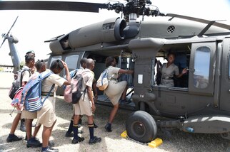 Students from Combermere School climb into a UH-60L Black Hawk helicopter from Florida Army National Guard B Company, 1-185th Assault Helicopter Battalion, on board Barbados’ Paragon Base. The students visited the base to participate in a Tradewinds 2017 community relations (COMREL) event that allowed local school children to meet with members of the armed forces from multiple participating countries, ask them questions, and check out their equipment up close. Tradewinds is a joint, combined exercise conducted in conjunction with partner nations to enhance the collective abilities of defense forces and constabularies to counter transnational organized crime, and to conduct humanitarian/disaster relief operations. (U.S. Navy photo by Mass Communication Specialist 1st Class Melissa K. Russell/Released)