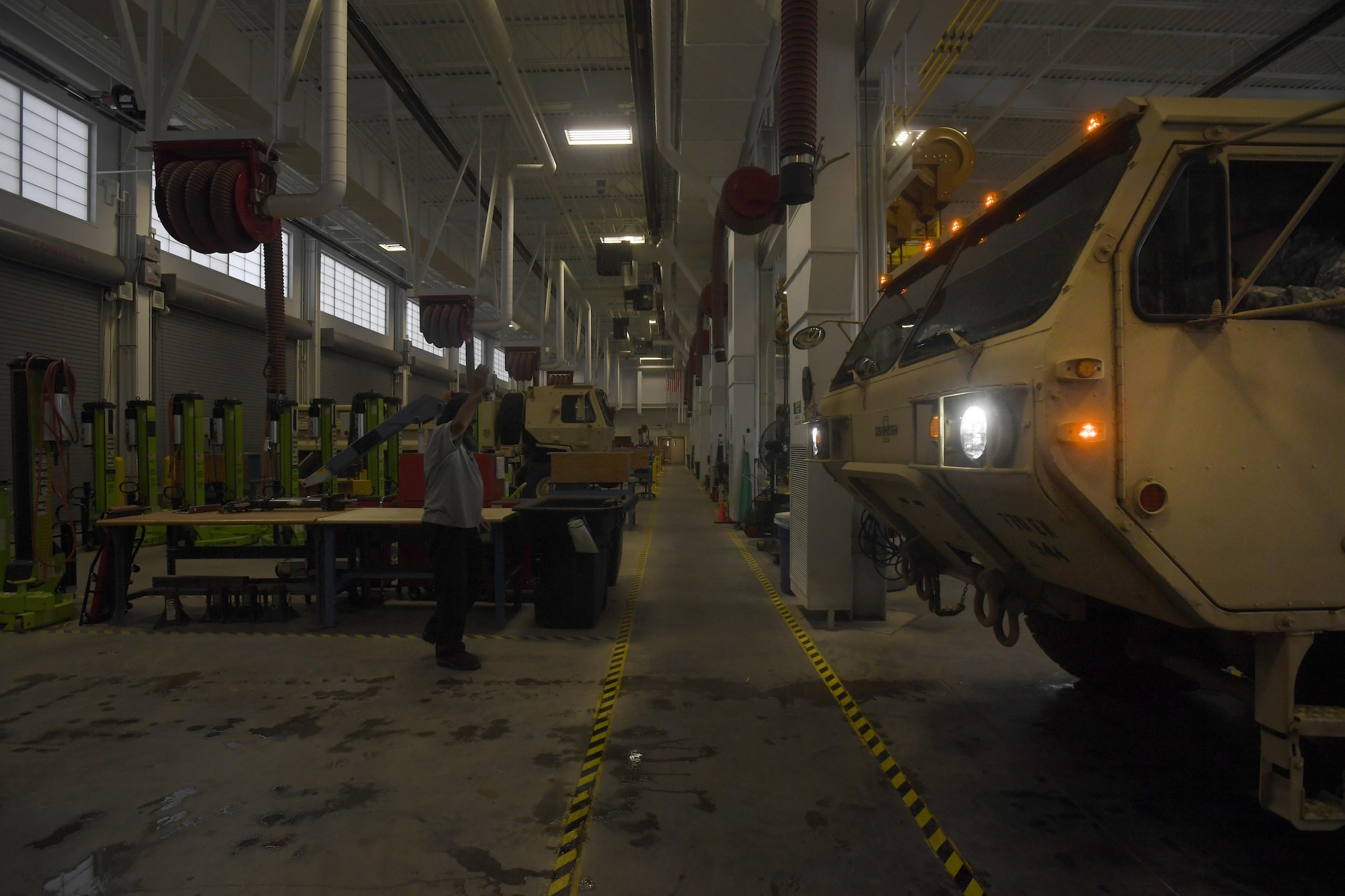 Machinists and automotive mechanics at the Army Support Activity Logistics Readiness Center escort a vehicle in an engineering bay at Joint Base McGuire-Dix-Lakehurst, New Jersey, June 7, 2017. The 38 active engineering bays see vehicles ranging from small all-terrain-vehicles from the 621st Contingency Response Wing to large vehicles able to carry a 60-ton tank.