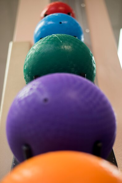 Medicine balls of various weights sit on a rack at the 27th Special Operations Medical Group Physical Medicine Office April 26, 2017, at Cannon Air Force Base, NM. Along with medicine balls, physical therapy offers resistance bands, free weights, stationary bikes, treadmills and various other pieces of equipment used for rehabilitation. (U.S. Air Force photo by Staff Sgt. Michael Washburn/Released)