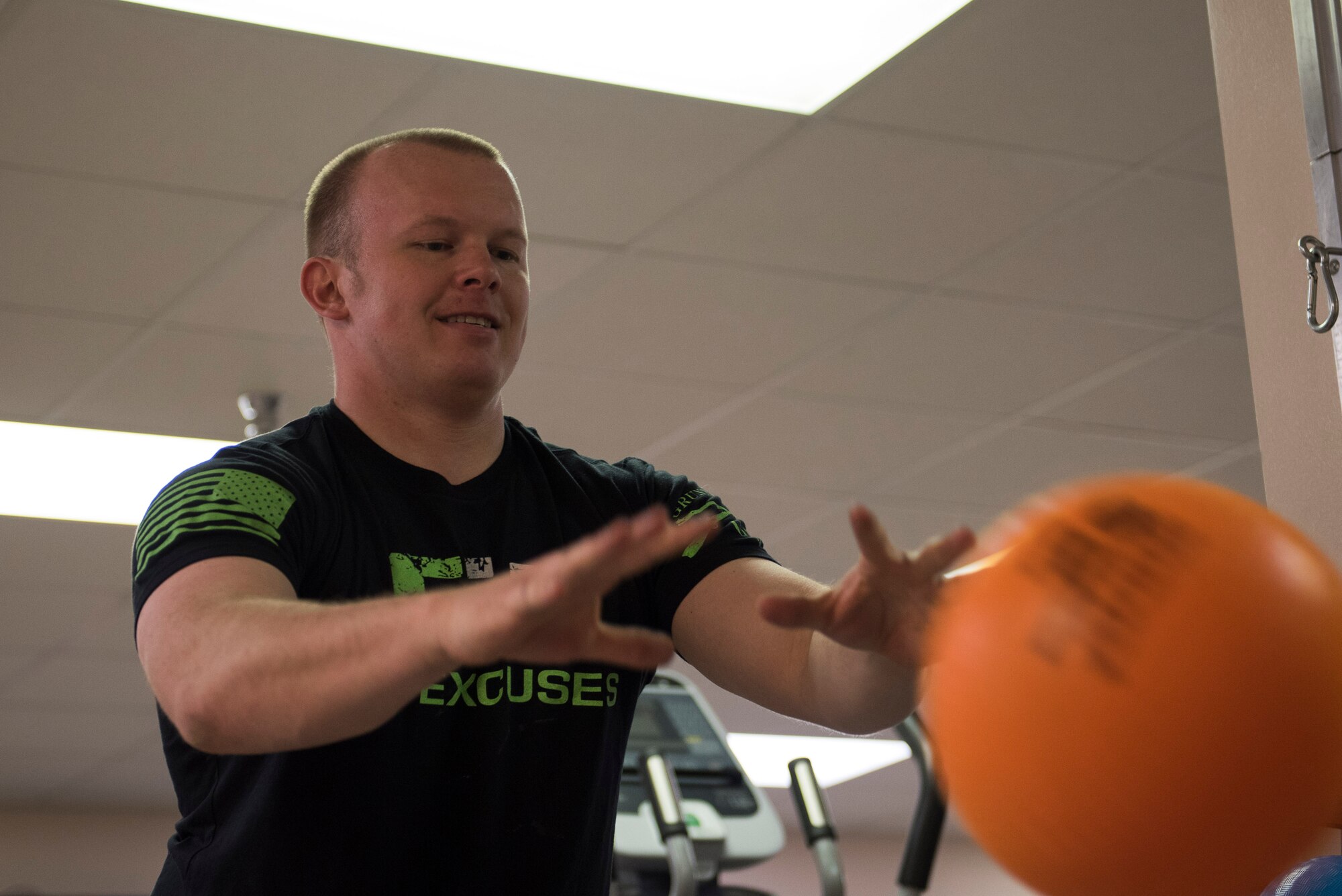 Casey Wheat, physical therapy patient, throws a medicine ball at the 27th Special Operations Medical Group Physical Medicine Office April 26, 2017, at Cannon Air Force Base, NM. Physical therapy may be needed for injuries from the wear and tear of day to day work, to post-operation surgeries. The different color bands have different resistances and patients can utilize the bands to increase the strength of the muscles in their arms or legs. (U.S. Air Force photo by Staff Sgt. Michael Washburn/Released)