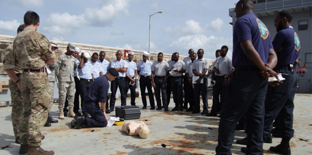 Bridgetown - Sapper Lee McAulay of the British Army guides members of the Trinidad & Tobago Coast Guard through a simulated first aid scenario during first aid training at Exercise Tradewinds 2017 in Bridgetown, Barbados, June 7, 2017. Tradewinds 2017 is a joint, combined exercise conducted in conjunction with partner nations to enhance the collective abilities of defense forces and constabularies to counter transnational organized crime, and to conduct humanitarian/disaster relief operations. (Royal Bahamas Defense Force photo by Marine Seaman Michael Turner/Released)