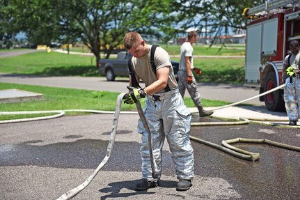 U.S. Air Force Staff Sergeant Zachary White, 612th Air Base Squadron, picks up equipment after a simulated call to action exercise in response to a fire emergency at Soto Cano Air Base, May 25th, 2017. Striving to maintain readiness among his team, he constantly teaches them the proper procedures to prepare and respond to an emergency situation. (U.S. Army photo by Maria Pinel)
