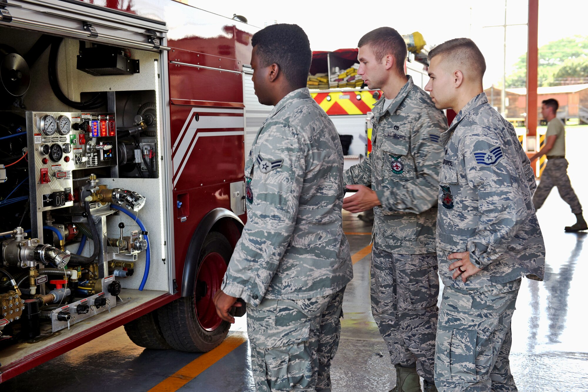 U.S. Air Force Staff Sergeant Zachary White (far right), 612th Air Base Squadron, shows Airman 1st Class Eric Van (left) and Senior Airman Eli Blue (center) how to properly check the Fire Department vehicles at Soto Cano Air Base, May 25th, 2017, to prevent any delays when exiting the Fire Department in response to a fire. Staff Sgt. White works as a Fire crew chief at Joint Task Force-Bravo’s Fire Emergency Services and is in charge of a four member team prepared to respond to an emergency situation on base.  (U.S. Army photo by Maria Pinel)