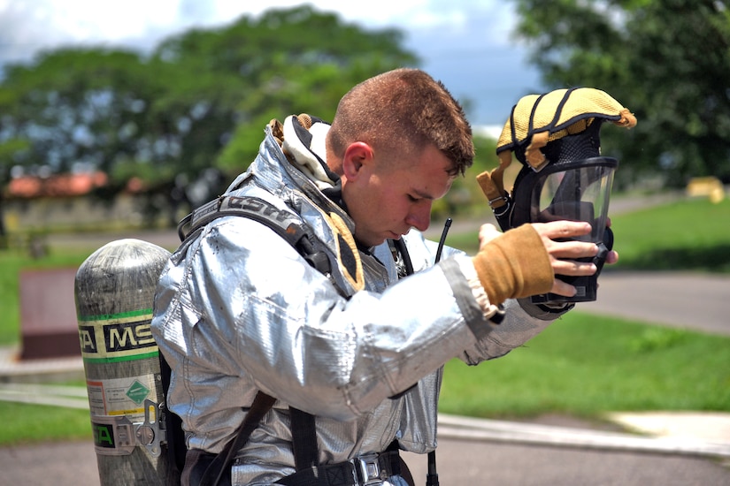 U.S. Air Force Staff Sergeant Zachary White, 612th Air Base Squadron, Fire Emergency Services crew chief, removes his protective gear during a simulated call to action exercise in response to a fire emergency at Soto Cano Air Base, May 25th, 2017. White works as a Fire crew chief at Joint Task Force-Bravo’s Fire Emergency Services with a team of four members and strives to make them perform their jobs the as best they can.  (U.S. Army photo by Maria Pinel)