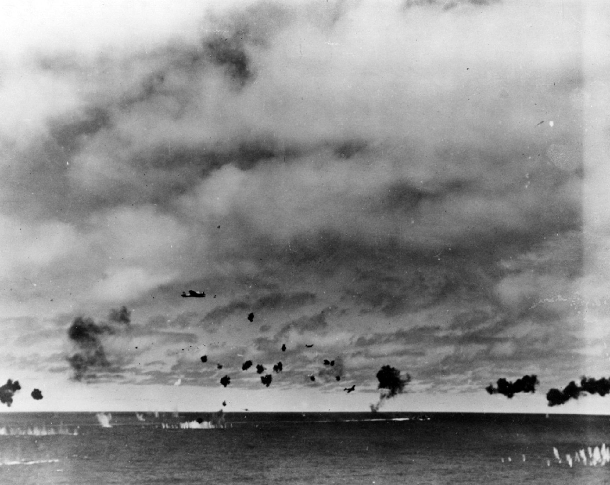 Japanese Type 97 shipboard attack aircraft from the carrier Hiryu amid heavy anti-aircraft fire, during the torpedo attack on USS Yorktown (CV-5) in the mid-afternoon, 4 June 1942. At least three planes are visible, the nearest clearly having already dropped its torpedo. The other two are lower and closer to the center, apparently withdrawing. Smoke on the horizon in right center is from a crashed plane. It is possible that the object very close to the horizon, in center, is another attacking aircraft. Official U.S. Navy Photograph, now in the collections of the U.S. National Archives.  Source:  (U.S. Navy)
