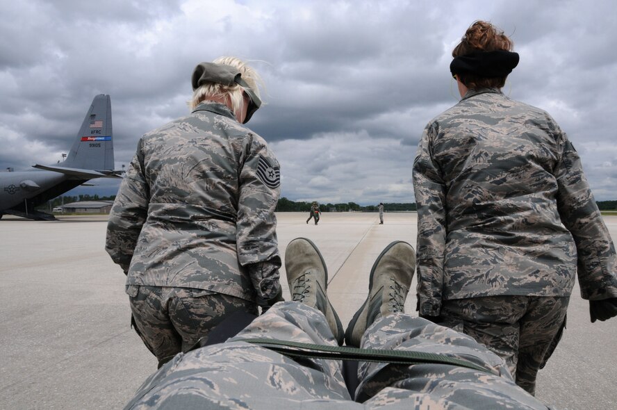 Citizen Airmen participating in the 445th Aeromedical Evacuation Squadron joint training mission here, carry a simulated patient to a C-130 Hercules, June 7, 2017. The 445th AES trained for two hours while airborne to simulate a real-world scenario. (U.S. Air Force photo/Senior Airman Joshua Kincaid)