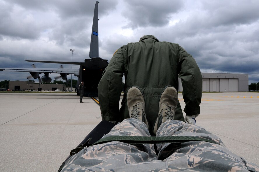 A Citizen Airman participating in the 445th Aeromedical Evacuation Squadron joint training mission, carries a simulated patient onto a C-130 Hercules here, June 7, 2017. The 445th AES trained for two hours while airborne to simulate a real-world scenario. (U.S. Air Force photo/Senior Airman Joshua Kincaid)