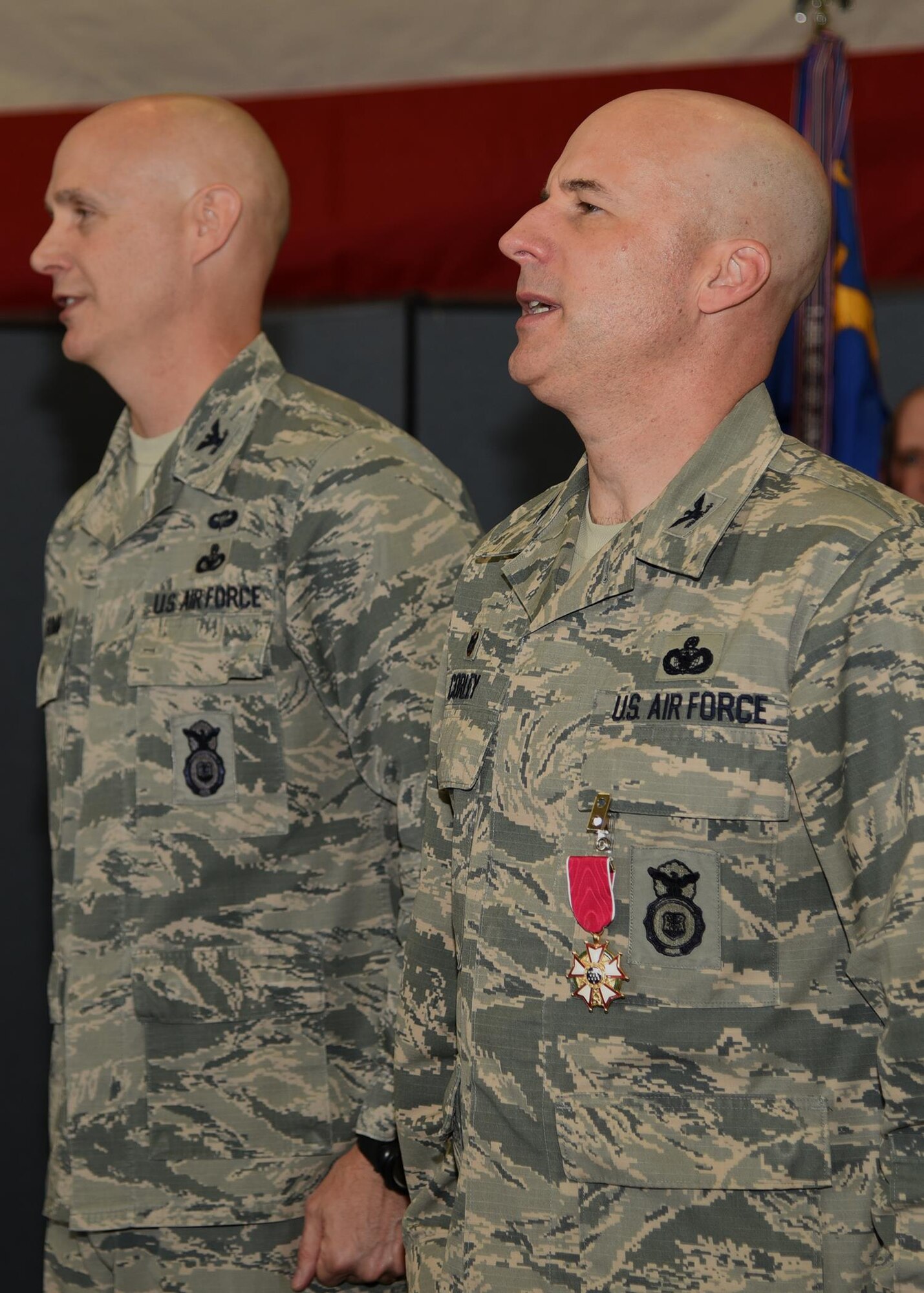 Colonel Chris Corley, outgoing Commander of the 90th Security Forces Group, and Col. John Grimm, sing the Air Force Song at the end of the 90th SFG Change of Command in the Peacekeeper High Bay on F.E. Warren Air Force Base, Wyo., June 9, 2017. Grimm assumed command of the group during the ceremony which represents a formal transition of authority from the outgoing commanding to the incoming commander. (U.S. Air Force photo by Glenn S. Robertson)