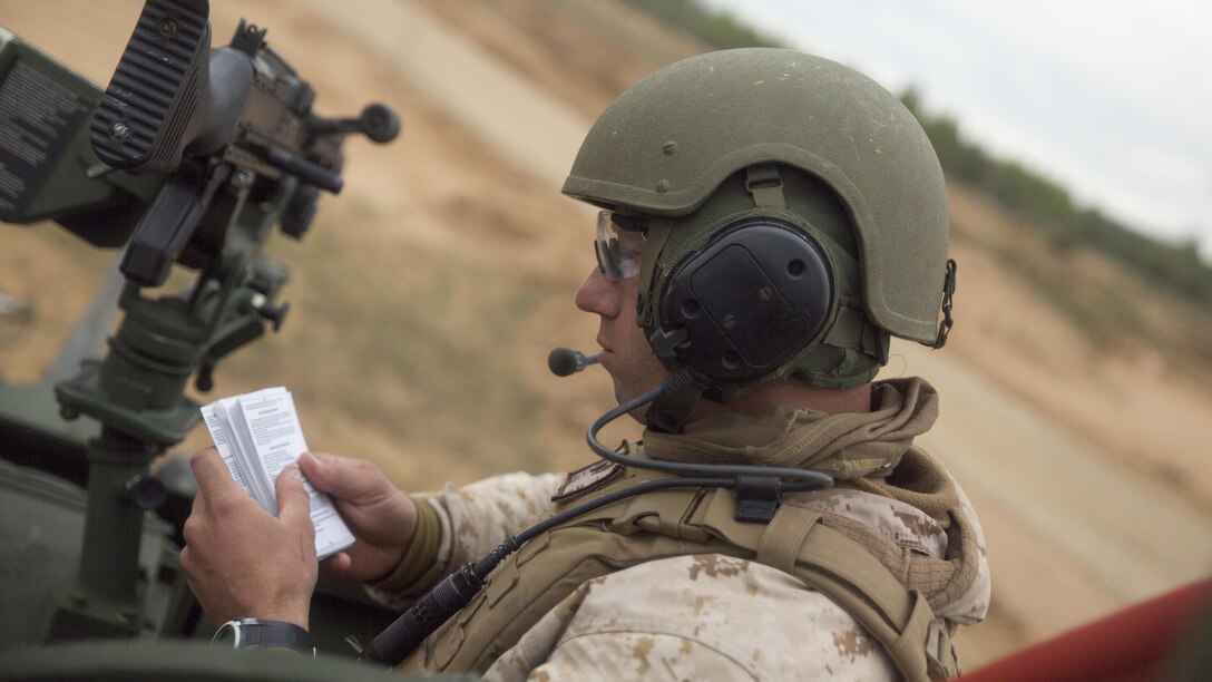 ADAZI, Latvia – Sgt. Christian Cook, a vehicle commander with Charlie Company, 4th Light Armored Reconnaissance Battalion, 4th Marine Division, Marine Forces Reserve, reads instructions to his crewmember before firing during Exercise Saber Strike 17 in the Adazi Training Area, Latvia, June 5, 2017. Exercise Saber Strike 17 is an annual combined-joint exercise conducted at various locations throughout the Baltic region and Poland. The combined training prepares NATO Allies and partners to effectively respond to regional crises and to meet their own security needs by strengthening their borders and countering threats. (U.S. Marine Corps photo by Cpl. Devan Alonzo Barnett/Released)