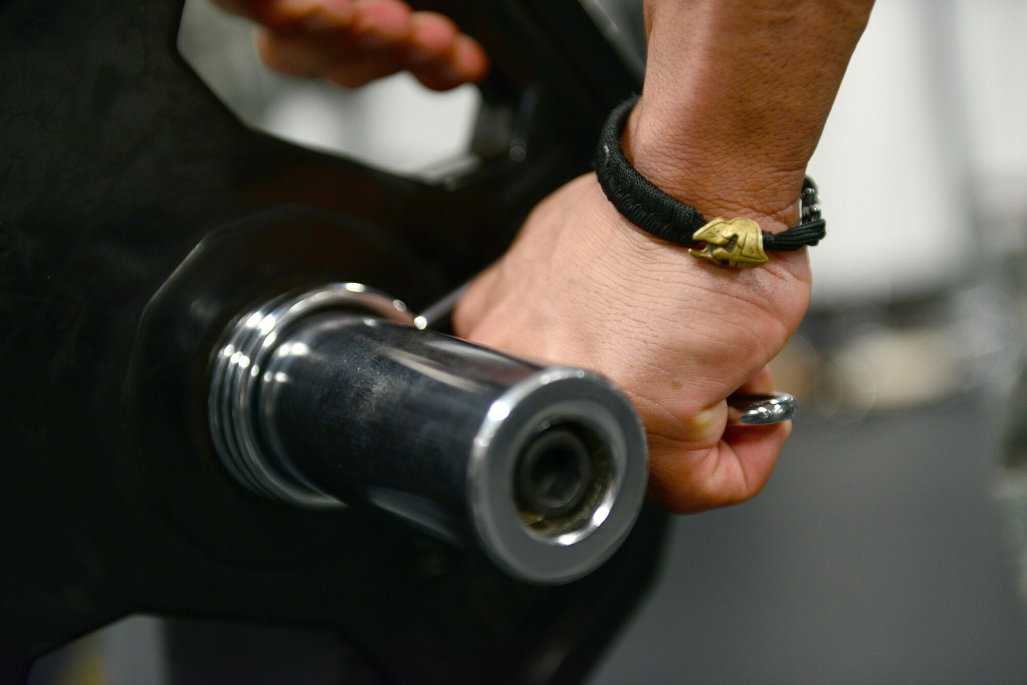 U.S. Air Force Tech Sgt. Ricardo Zuniga, a weapons load crew member from the 131st Aircraft Maintenance Squadron, fastens a clamp on a curl bar while working out at the new flightline gym at Whiteman Air Force Base, Mo., May 30, 2017. The new flightline gym features two treadmills, an elliptical and a row machine, a D-Gym multiuse station, free weights, incline, decline and flat benches, a Smith Machine, and spin bikes. It also features newly mounted fans on the walls, and a sound system equipped with satellite radio. (U.S. Air Force photo by Senior Airman Joel Pfiester)
