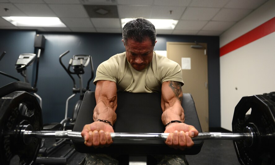 U.S. Air Force Tech. Sgt. Ricardo Zuniga, a weapons load crew member from the 131st Aircraft Maintenance Squadron, performs preacher curls in the new flightline gym at Whiteman Air Force Base, Mo., May 30, 2017. The new flightline gym features two treadmills, an elliptical and a row machine, a D-Gym multiuse station, free weights, incline, decline and flat benches, a Smith Machine, and spin bikes. It also features newly mounted fans on the walls, and a sound system equipped with satellite radio. (U.S. Air Force photo by Senior Airman Joel Pfiester)