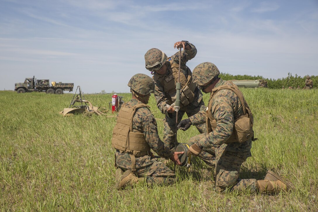 Cpl. Yasuey Gonzalez (left), Pfc. Robert Garcia (center), and Staff Sgt. Brian Beamer (right), bulk fuel specialists with Marine Wing Support Squadron 473, 4th Marine Aircraft Wing, Marine Forces Reserve, hammer a grounding rod into the earth at the Canadian Manoeuvre Training Centre during exercise Maple Flag 50, May 31, 2017. MWSS-473 is providing real world refueling support to Royal Canadian Air Force CH-147 Chinook and CH-146 Griffon type model series during exercise Maple Flag 50. (U.S. Marine Corps photo by Lance Cpl. Niles Lee/Released)