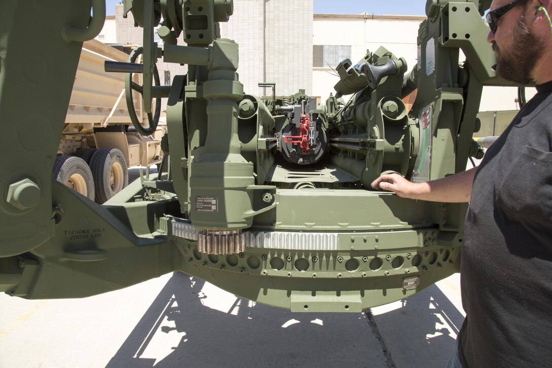 David Vierheller, artillery repair specialist, points out the breech on the M777 howitzer lift gun. It is painted red to indicate it is a nonfiring version of the cannon and is used only for purposes of training helicopter pilots and rigging crews how to transport the nearly five ton gun by air.