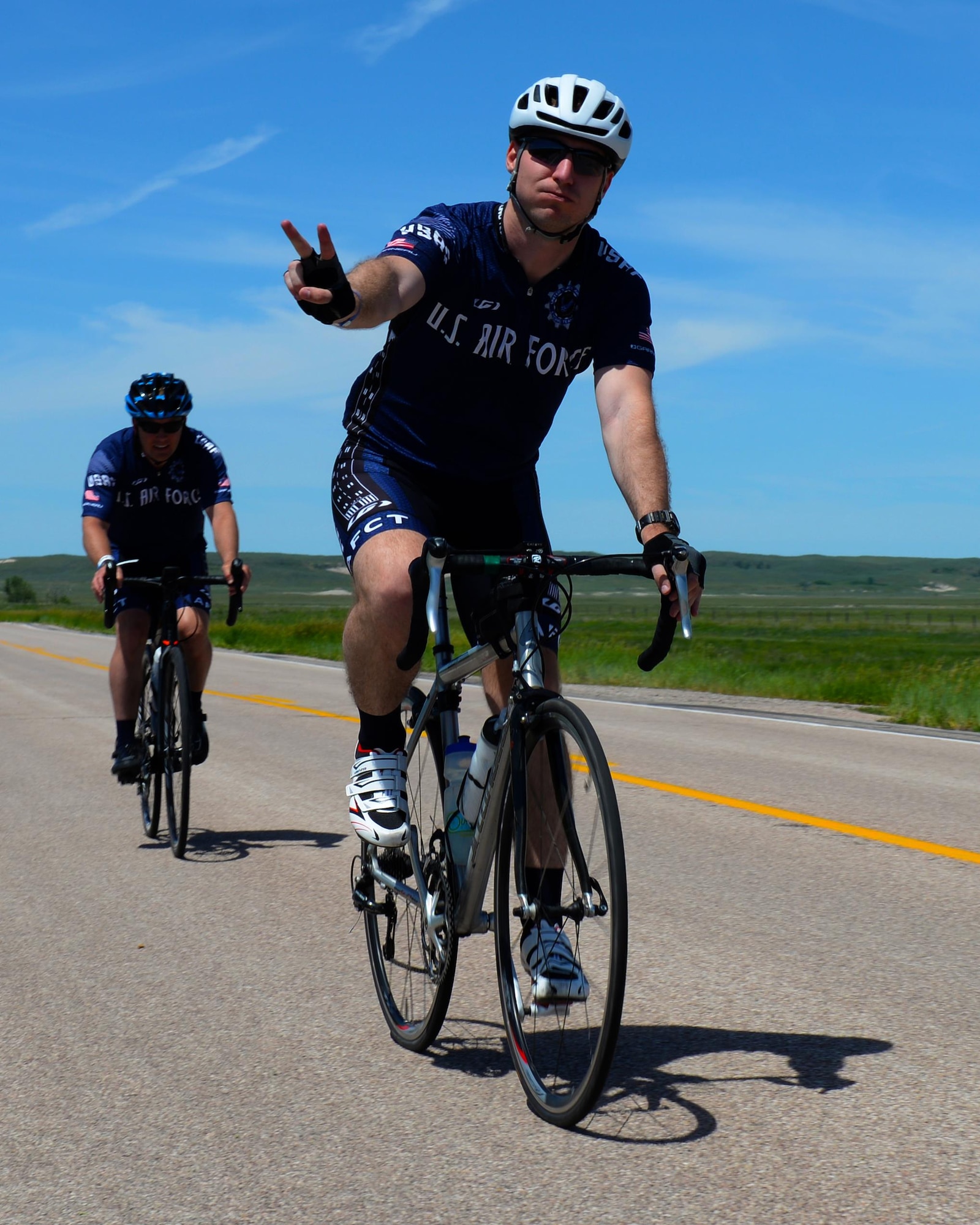 Capt. Eben Egler, a B-1 bomber weapon systems officer assigned to the 34th Bomb Squadron, and Maj. Anthony Bares, the director of inspections assigned to the 28th Bomb Wing Inspector General office, ride through the fourth pit stop during the Ride Across South Dakota bike tour near Scenic, S.D., June 4, 2017. During the first day of RASDAK, the ride included seven pit stops located eight to 20 miles away from each other over the span of 74 miles. (U.S. Air Force photo by Airman Nicolas Z. Erwin)