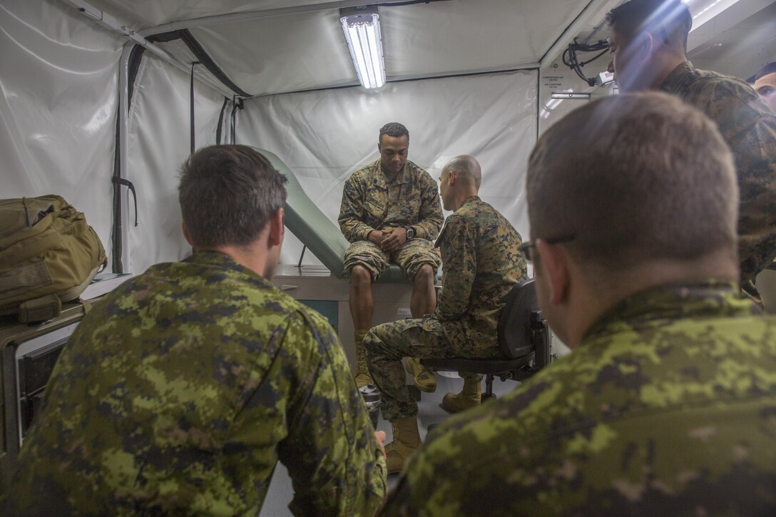 Canadian medical technicians and U.S. Navy corpsmen watch as U.S. Navy Lt. Cmdr. Christian Basque, a navy doctor with Marine Wing Support Squadron 472, Marine Aircraft Group 49, 4th Marine Aircraft Wing, Marine Forces Reserve, examines U.S. Marine Corps Sgt. Joshua Edmonson, a communications Marine with MWSS-473, MAG-41, 4th MAW, MARFORRES, during exercise Maple Flag 50 at Canadian Forces Base Cold Lake, Alberta, June 2, 2017. During Maple Flag 50, the corpsmen’s mission was to provide medical support for Marines with MWSS-473 by conducting field medical assessments. (U.S. Marine Corps photo by Lance Cpl. Niles Lee/Released)