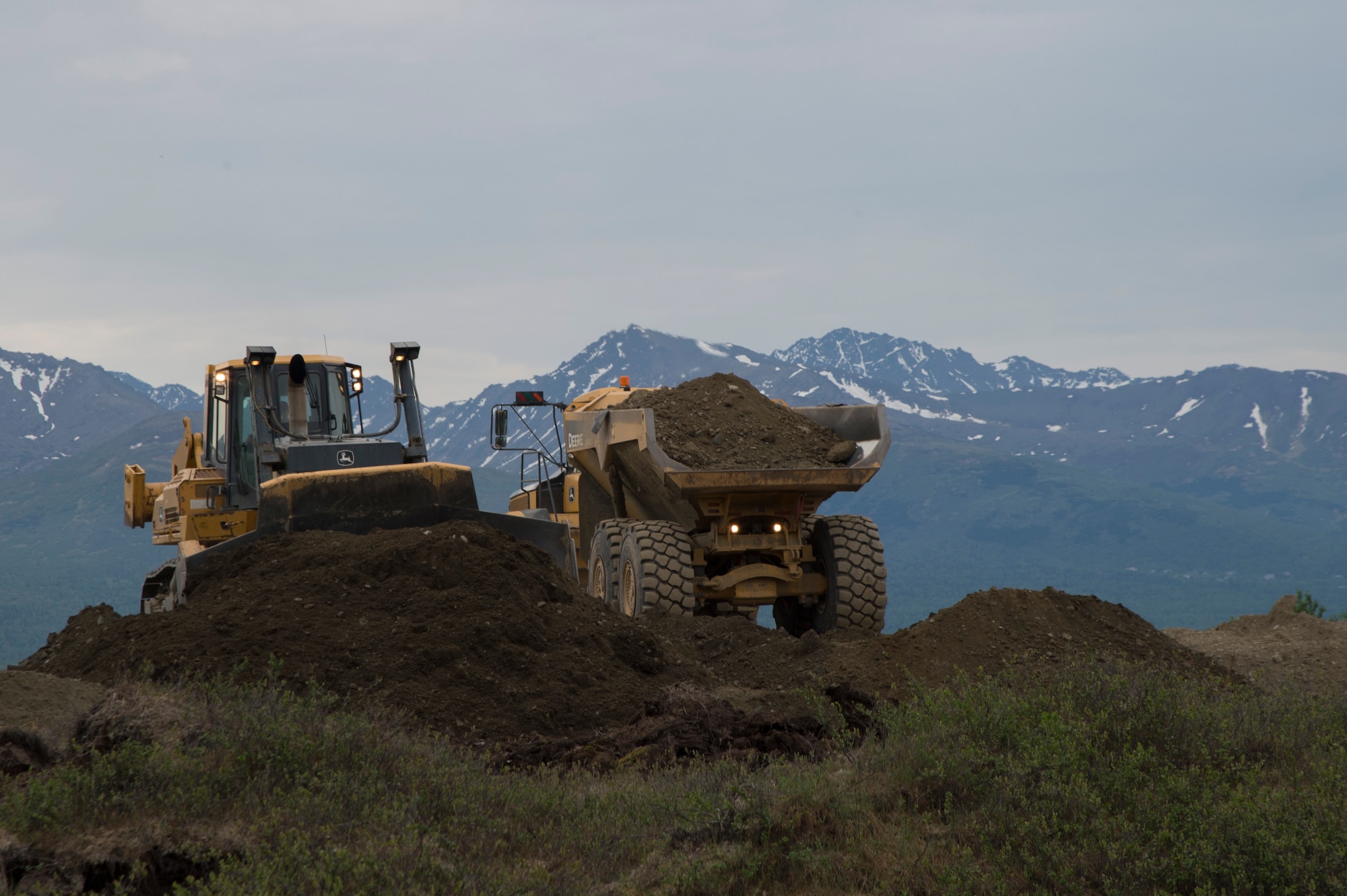 Members of the 819th RED HORSE Squadron operate an excavator, bulldozer and a dump trucks  during Phase I of the north-south runway at Joint Base Elmendorf-Richardson, Alaska, June 9, 2017. During their three-month stay, they play to move a minimum of 850,000 cubic yards. (U.S. Air Force photo by Staff Sgt. Sheila deVera)