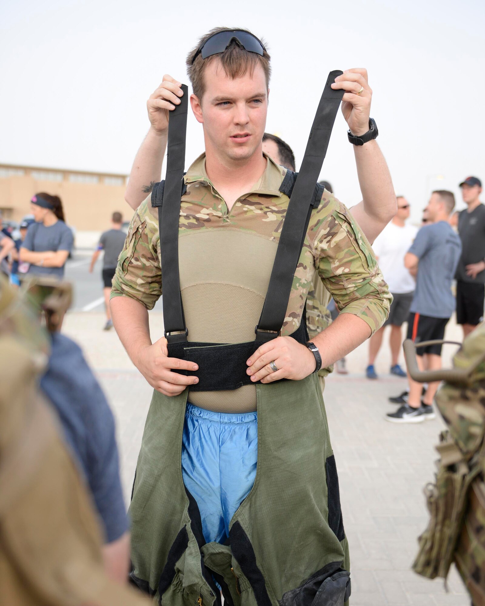 U.S. Air Force Staff Sgt. Brent Points, explosive ordinance disposal technician, assigned to the 379th Civil Engineering Squadron, gets help donning the bomb suit he will wear during the annual EOD 5K Memorial Run at Al Udeid Air Base, Qatar, June 3, 2017. Points joined fellow EOD members along with service members from across the base to take part in the EOD 5K Memorial Run in memory of the EOD men and women killed in action during combat operations. (U.S. Air Force photo by Tech. Sgt. Bradly A. Schneider/Released)