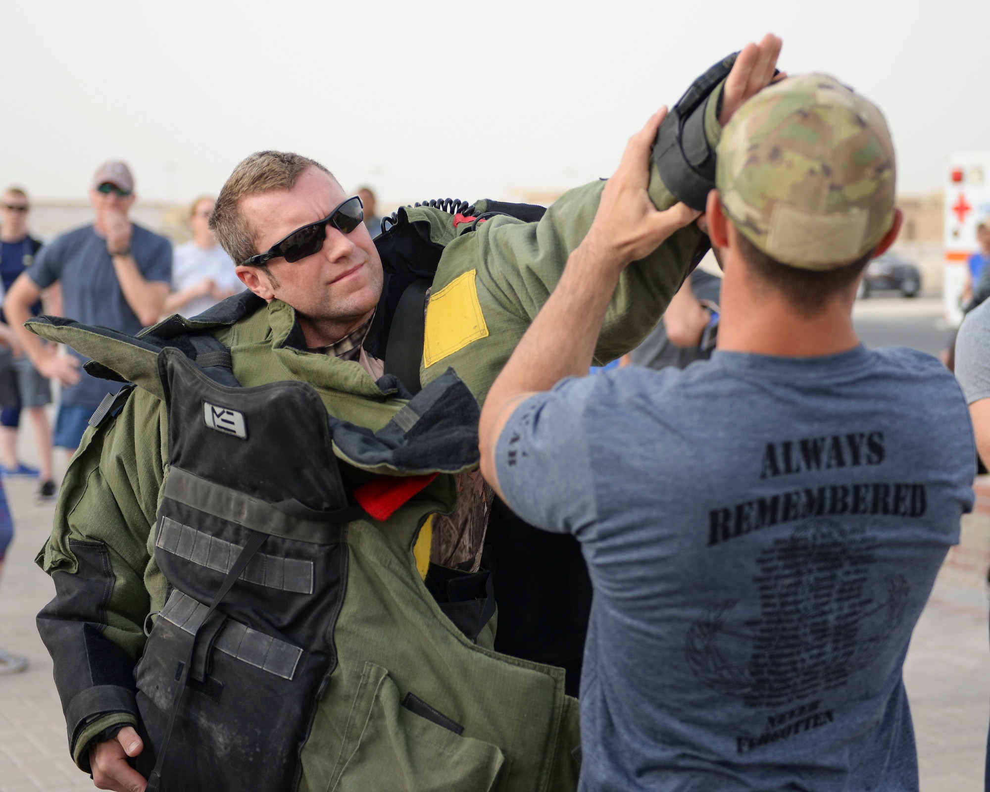 U.S. Air Force Staff Sgt. Jason Evans, explosive ordinance disposal technician, assigned to the 379th Civil Engineering Squadron, gets help donning the bomb suit he will wear during the annual EOD 5K Memorial Run at Al Udeid Air Base, Qatar, June 3, 2017. Evans joined service members from across the base who gathered to take part in the EOD 5K Memorial Run in memory of the EOD men and women killed in action during combat operations. (U.S. Air Force photo by Tech. Sgt. Bradly A. Schneider/Released)