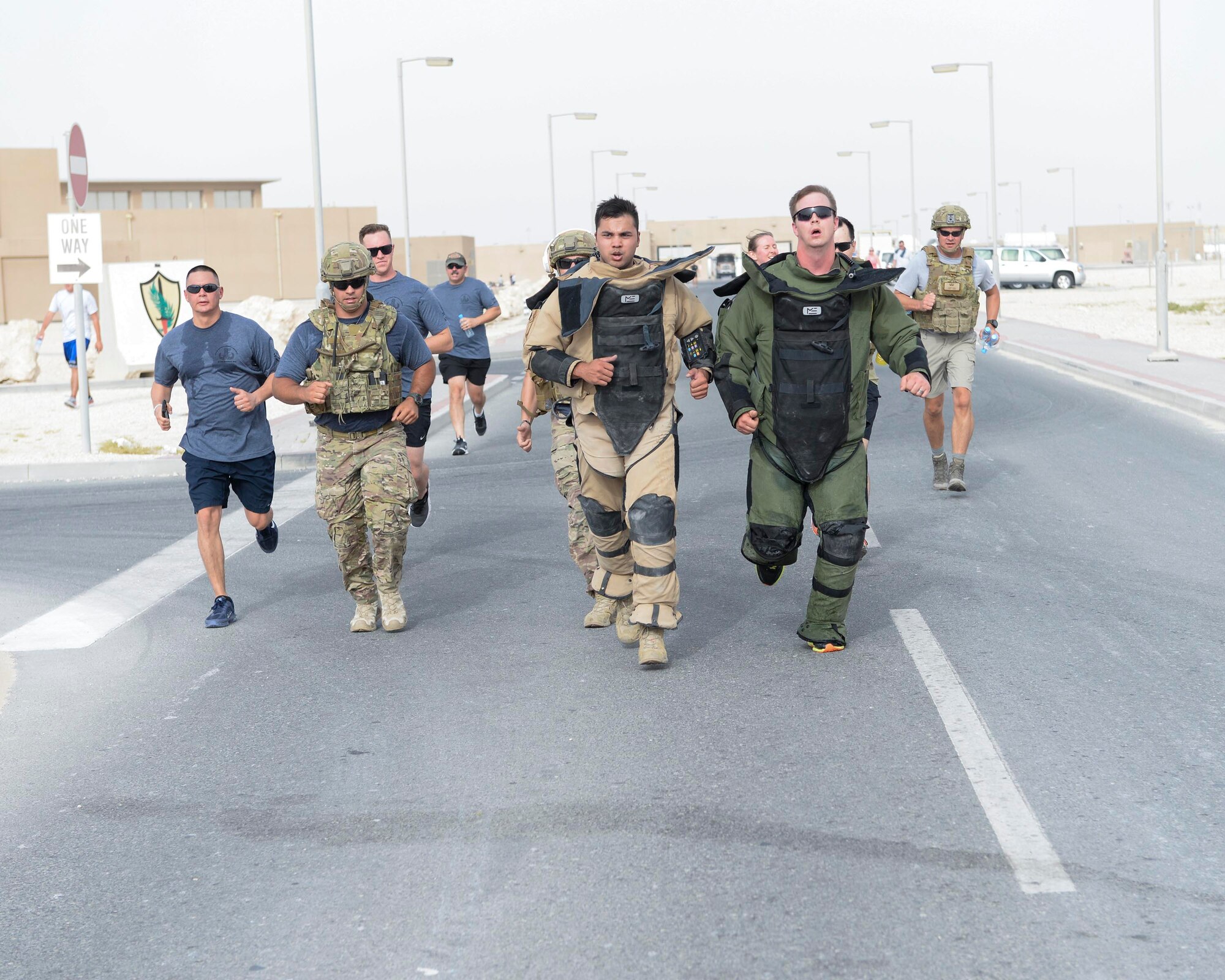 U.S. Air Force Senior Airman Cory McLellan, left, tan bomb suit, and Staff Sgt. Brent Points, right, green bomb suit, explosive ordinance technicians assigned to the 379th Civil Engineering Squadron approach the finish line while wearing bomb suits during the annual EOD 5K Memorial Run at Al Udeid Air Base, Qatar, June 3, 2017. McLellan and Points joined service members from across the base who gathered to take part in the EOD 5K Memorial Run in memory of the EOD men and women killed in action during combat operations. (U.S. Air Force photo by Tech. Sgt. Bradly A. Schneider/Released)