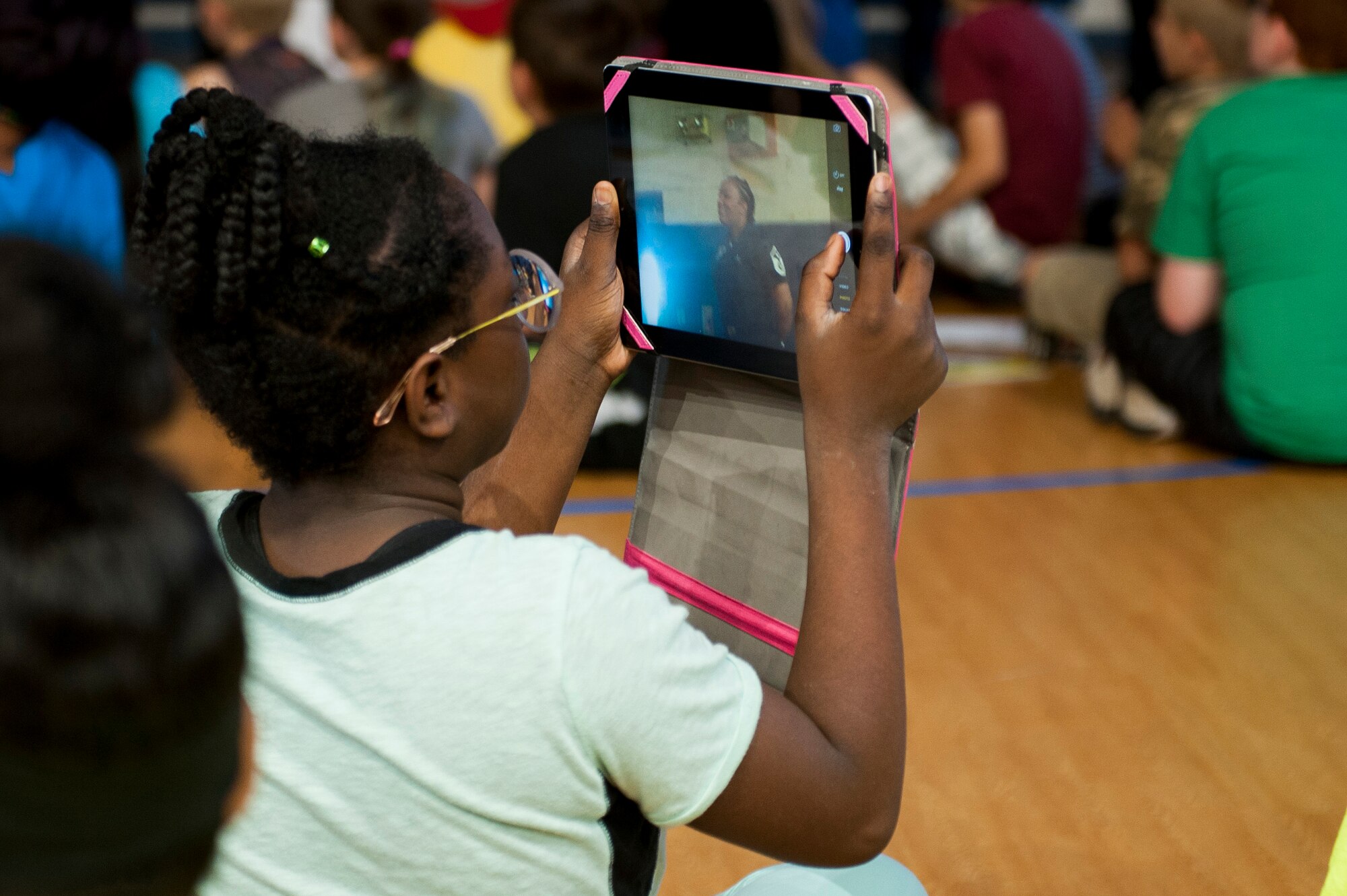 A child takes a photo of Master Sgt. Ira Jack, Thunderbirds first sgt., during a presentation at Scott Air Force Base, Ill., June 9, 2017. The United States Air Force Thunderbirds visited the youth center and spoke with military children about the importance of teamwork and trust. (U.S. Air Force photo by Staff Sgt. Clayton Lenhardt)