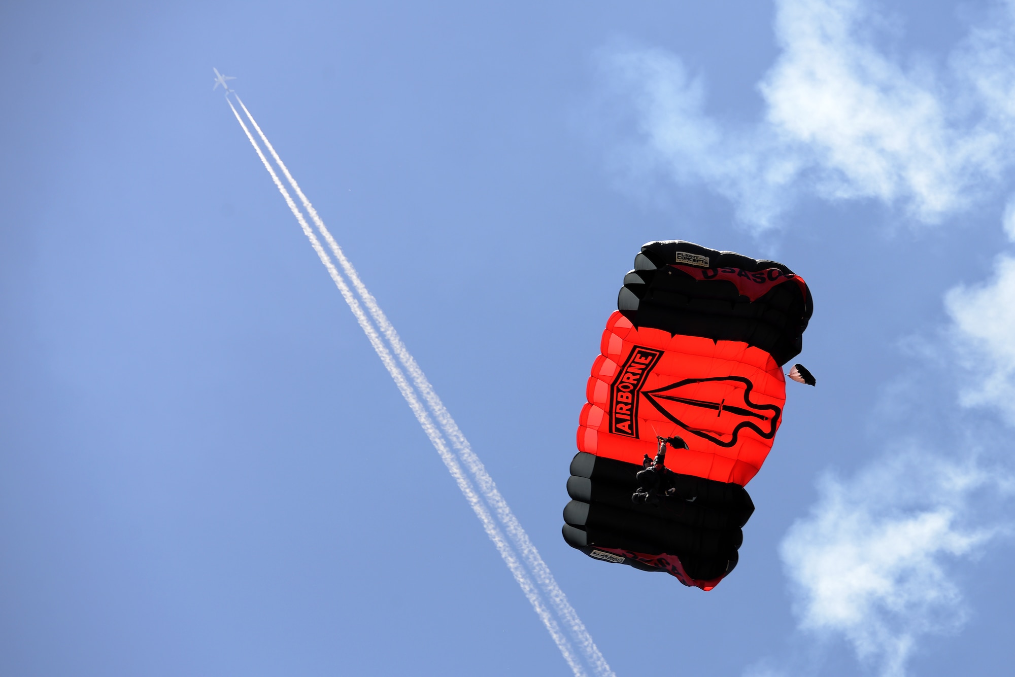 Members of the Black Daggers, the official U.S. Army Special Operations Command Parachute Demonstration Team, perform aerial stunts during Scott Air Force Base 2017 Air Show and Open House June 9, 2017, which celebrates the base’s 100th anniversary.  Black Daggers are highly trained Soldiers who insert themselves behind enemy lines to disrupt the movement of enemy troops and supplies to the front lines.  They frequently use parachutes to infiltrate without being detected. (U.S. Air Force photo by Tech. Sgt. Jonathan Fowler)