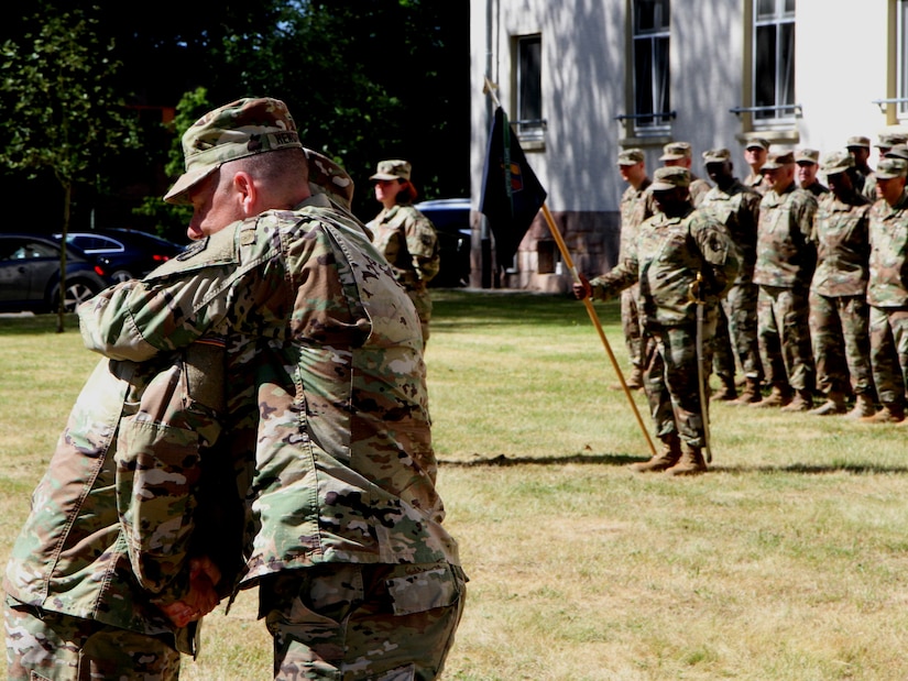 Maj. Paul M. Nuernberg (left), the outgoing commander of Headquarters and Headquarters Company, 7th Mission Support Command, hugs HHC’s outgoing senior enlisted leader, 1st Sgt. Roderick W. Hendricks, after the unit’s change of command and change of responsibility ceremony Saturday June 10, 2017 at Daenner Kaserne in Kaiserslautern, Germany. 