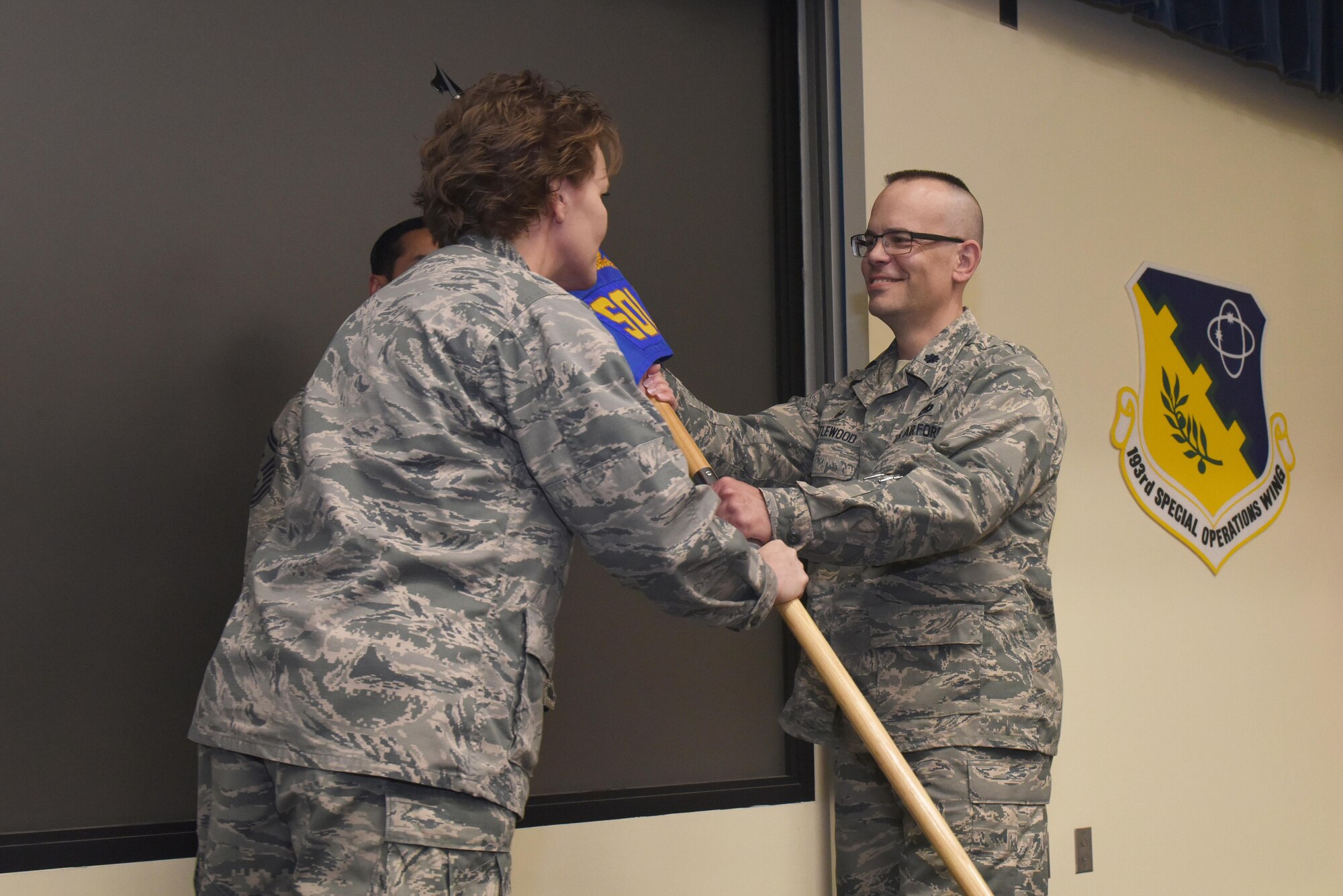 Lt. Col. Susan Garrett, commander, 193rd Special Operations Mission Support Group, presents the guidon to Lt. Col. Keith Littlewood, the new 193rd Special Operations Logistics Readiness Squadron commander, during an assumption of command ceremony June 11, 2017. The ceremony began with preliminary honors and concluded with the symbolic passing of the guidon. (U.S. Air National Guard photo by Tech. Sgt. Claire Behney/Released)