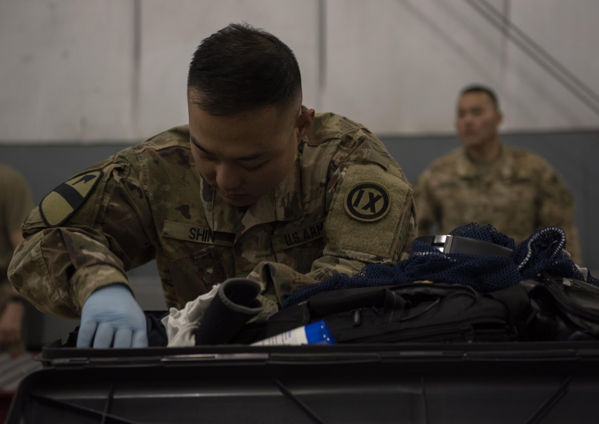 U.S. Army Spc. Jong Wook Shin, 368th Military Police Company, inspects the contents of a piece of luggage at Bagram Airfield, Afghanistan, April 30, 2017. During their inspections, the customs team follows strict guidelines of multiple governmental agencies to include the U.S. Customs and Border Protection, U.S. Department of Agriculture and Bureau of Alcohol, Tobacco, Firearms and Explosives when searching through luggage.  (U.S. Air Force photo by Staff Sgt. Benjamin Gonsier) 