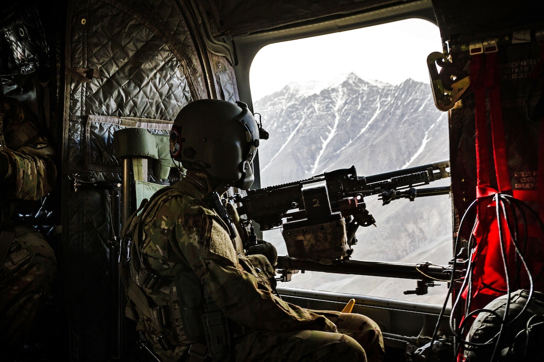 An Army crew chief peers from the side window of a CH-47 Chinook helicopter near Mazar-e-Sharif, Afghanistan, June 9, 2017. Army photo by Capt. Brian Harris