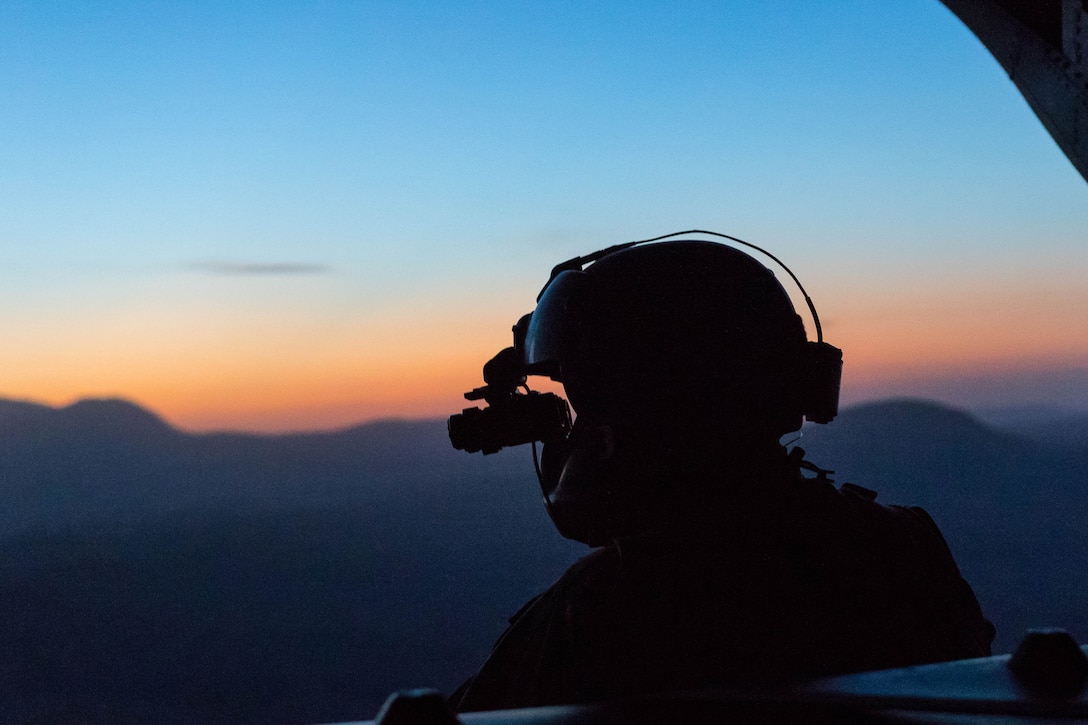An Army crew chief scans the terrain at sunset from the back of a CH-47 Chinook helicopter near Mazar-e-Sharif, Afghanistan, June 9, 2017. Army photo by Capt. Brian Harris