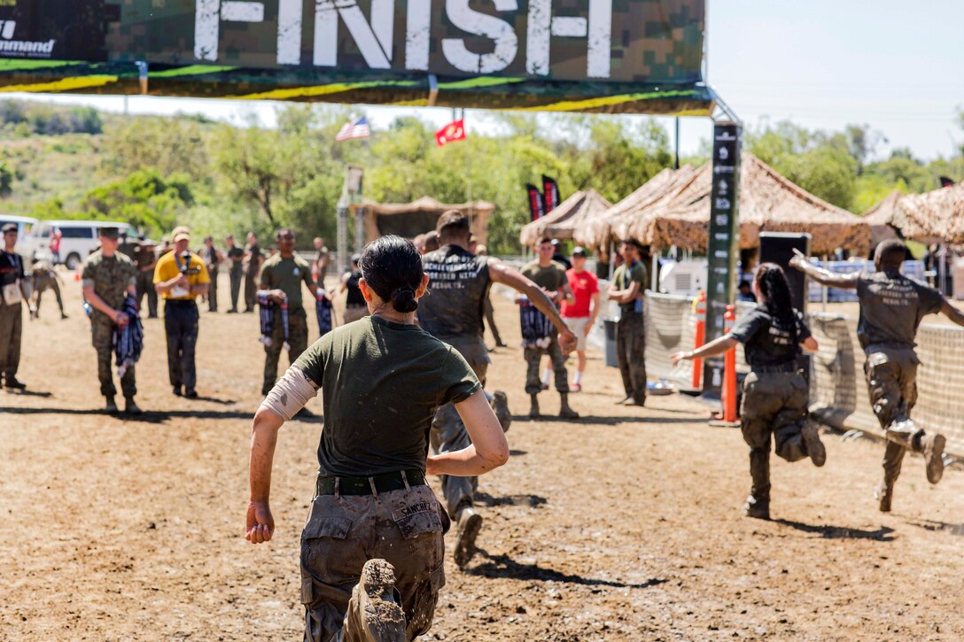 Marines and sailors run to the finish line of the 2017 Marine Corps Mud Run by Lake O'Neill at Camp Pendleton, Calif, June 9, 2017. Marine Corps photo by Sgt. Hector de Jesus
