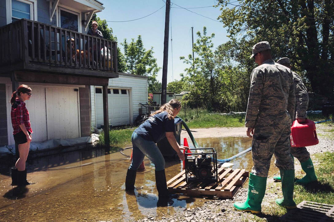 New York Air National Guardsmen setup a pump that will remove water from the basement of a local home in Olcott, N.Y., June 8, 2017. Air National Guard photo by Staff Sgt. Ryan Campbell
