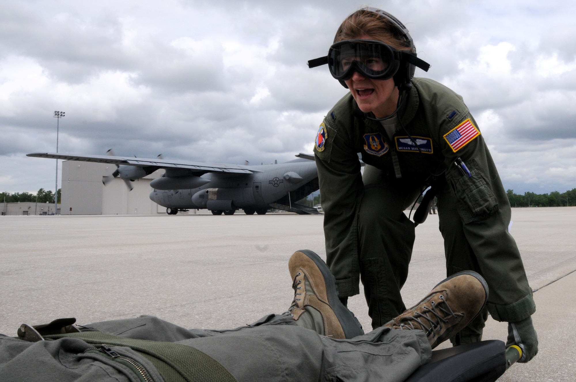 445th Aeromedical Evacuation Squadron crew member, 1st Lt. Megan Mancinotti, gives orders to lift a simulated patient for a joint training mission here, June 7, 2017. The 445th AES trained for two hours while airborne to simulate a real-world scenario. (U.S. Air Force photo/Senior Airman Joshua Kincaid)