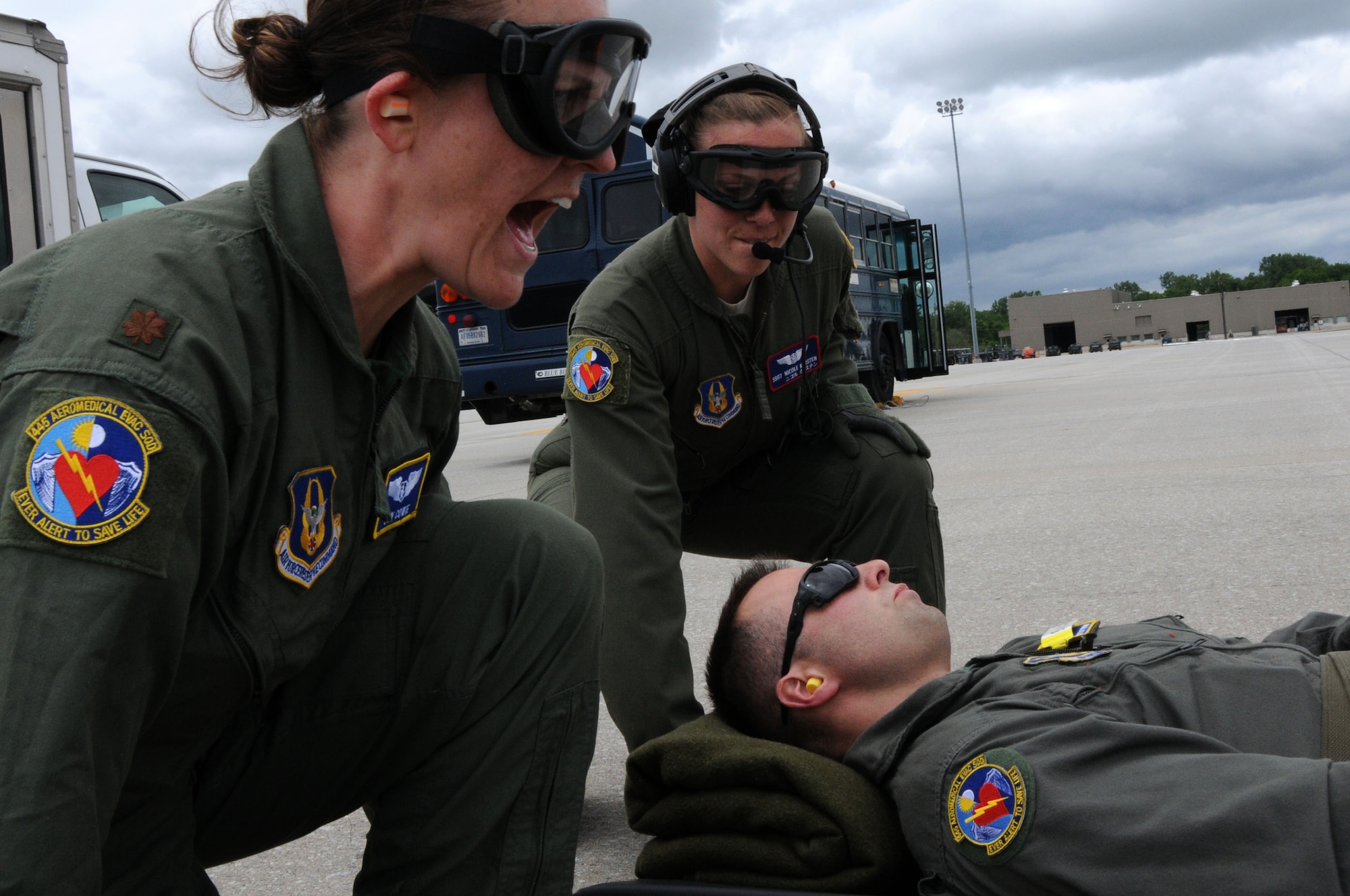 445th Aeromedical Evacuation Squadron crew members, Maj. Jen Cowie (left) and Staff Sgt. Nicole Karsten (right), prepare to lift a Citizen Airman simulating a patient for a joint training mission here, June 7, 2017. The 445th AES trained for two hours while airborne to simulate a real-world scenario. (U.S. Air Force photo/Senior Airman Joshua Kincaid)