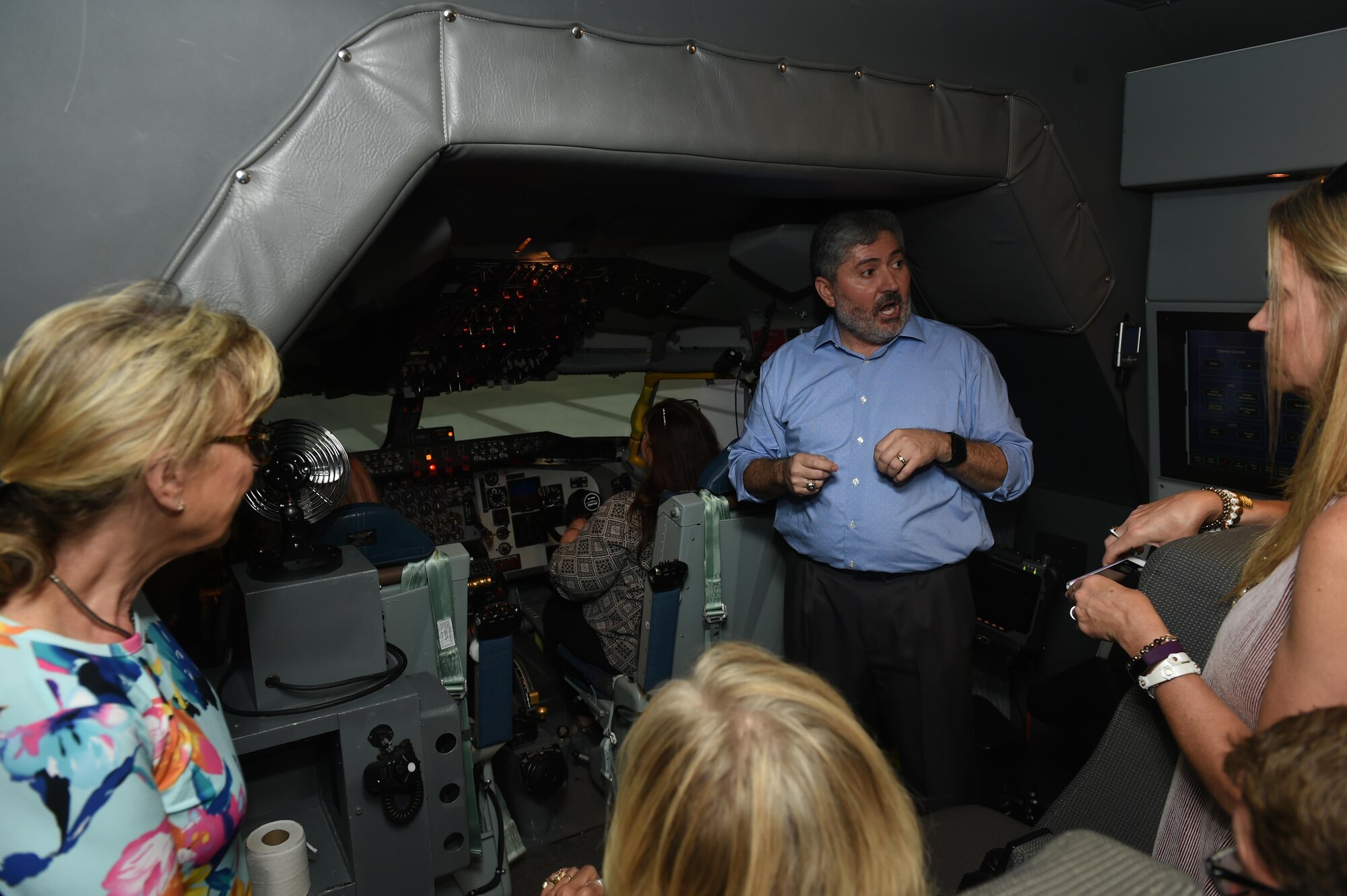 Tony Valerio, CAE Systems instructor pilot, show the 2017 Altus honorary commanders a pilot simulator for the U.S. Air Force KC-135 Stratotanker during an immersion tour, May 31, 2017 at Altus Air Force Base, Oklahoma. The honorary commanders took turns flying and landing the simulator to demonstrate the capability of the training system during their Immersion tour. (U.S. Air Force Photo by Senior Airman Kirby Turbak/Released.)