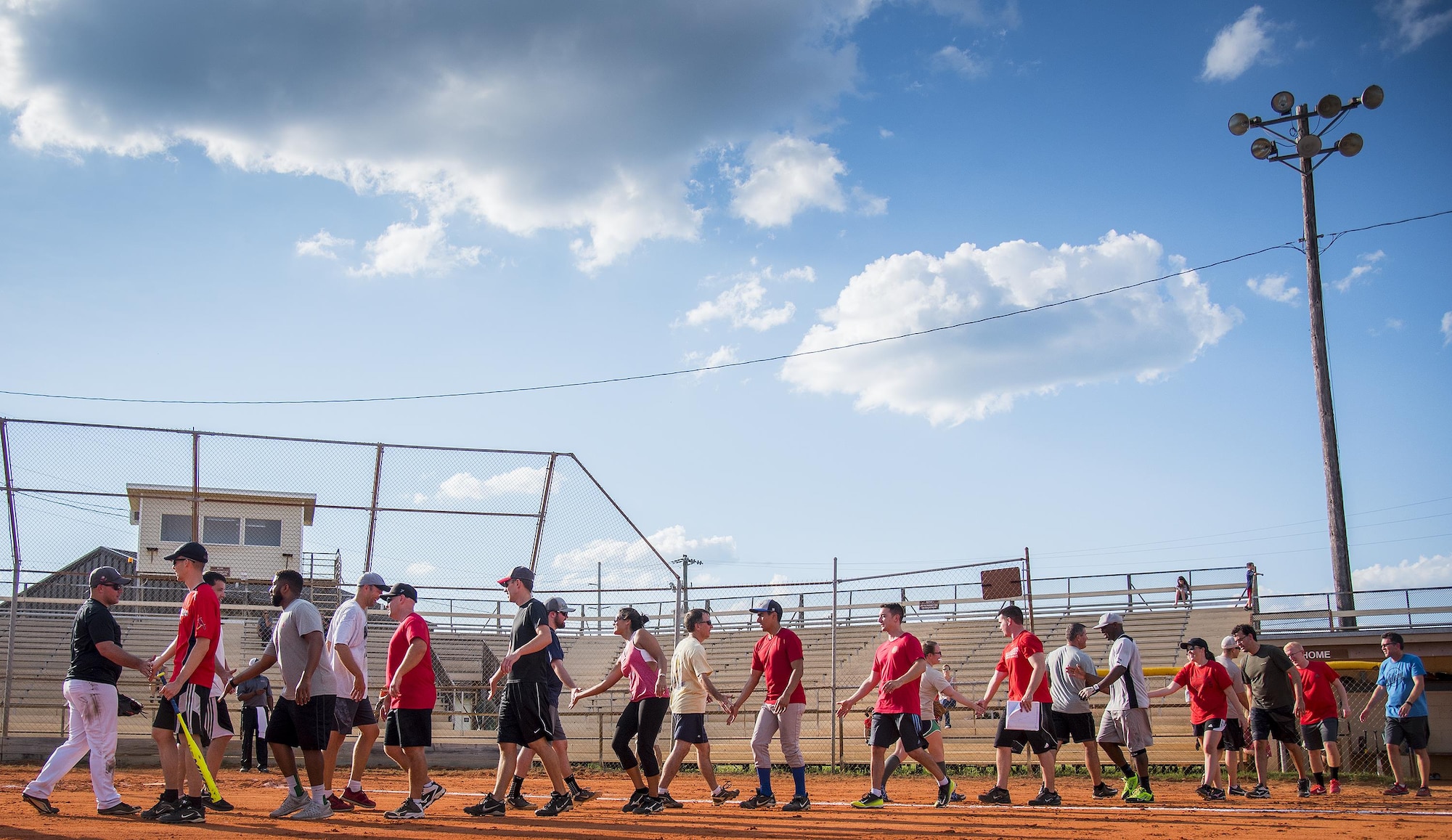 The first Thursday intramural softball game comes to an end under a blue sky at Eglin Air Force Base, Fla., June 8.  The Armament Directorate team (left) bashed the hapless Air Force Research Lab team (right) 14-4 in five innings of play.  (U.S. Air Force photo/Samuel King Jr.)